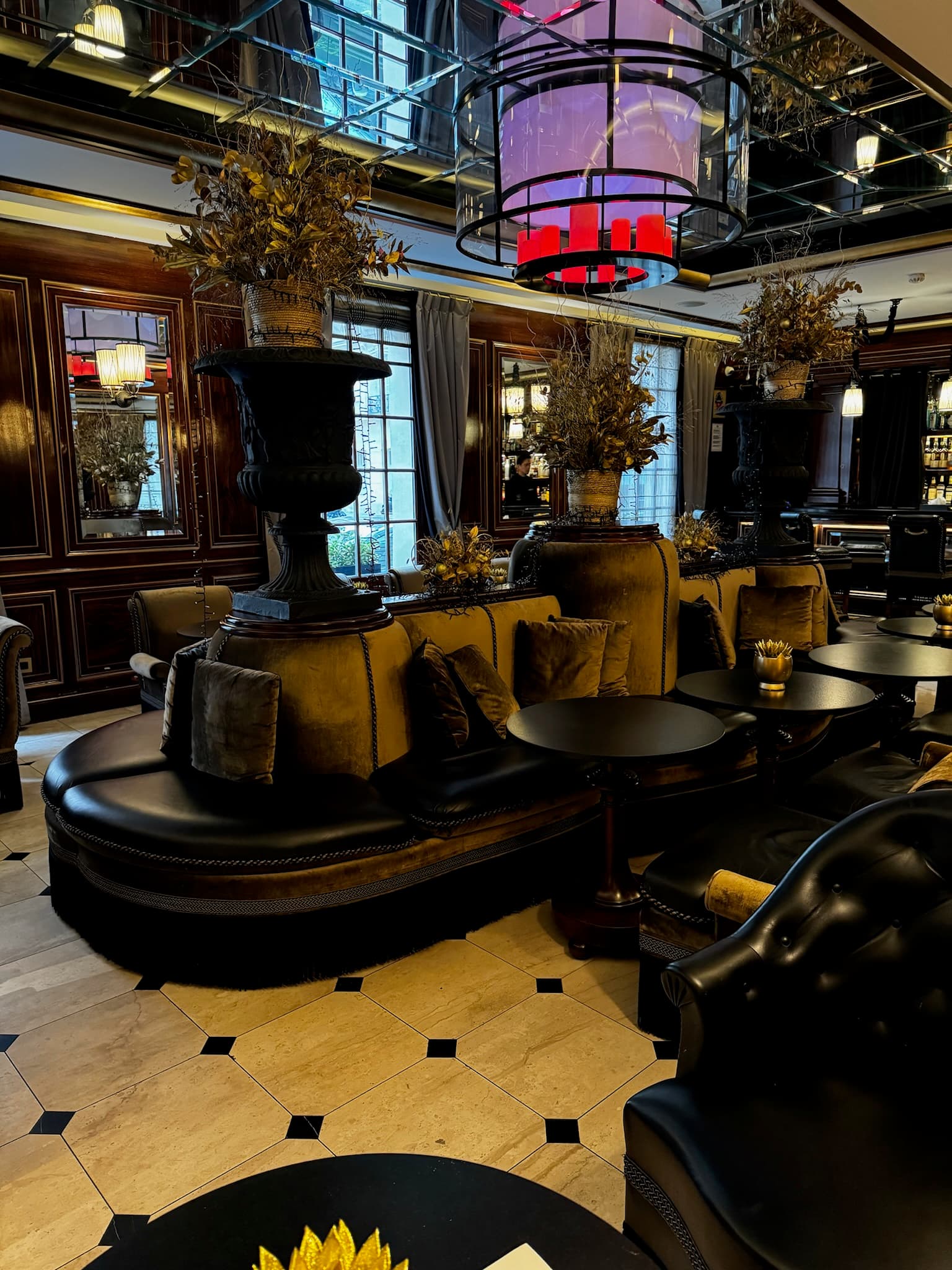 The hotel lobby, with black couches and tables and a black and white marble floor