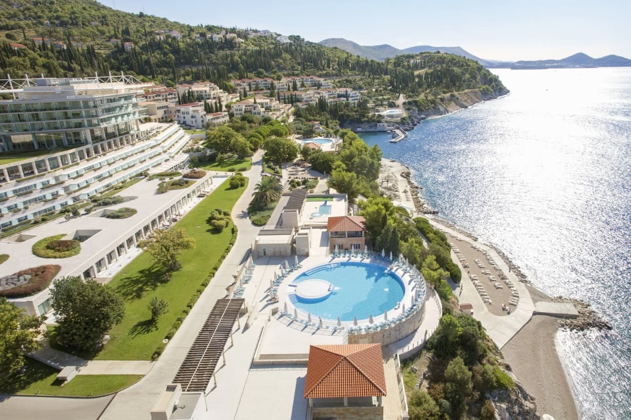 wide shot of hotel on the Croatian coast with a pool and views of the sea