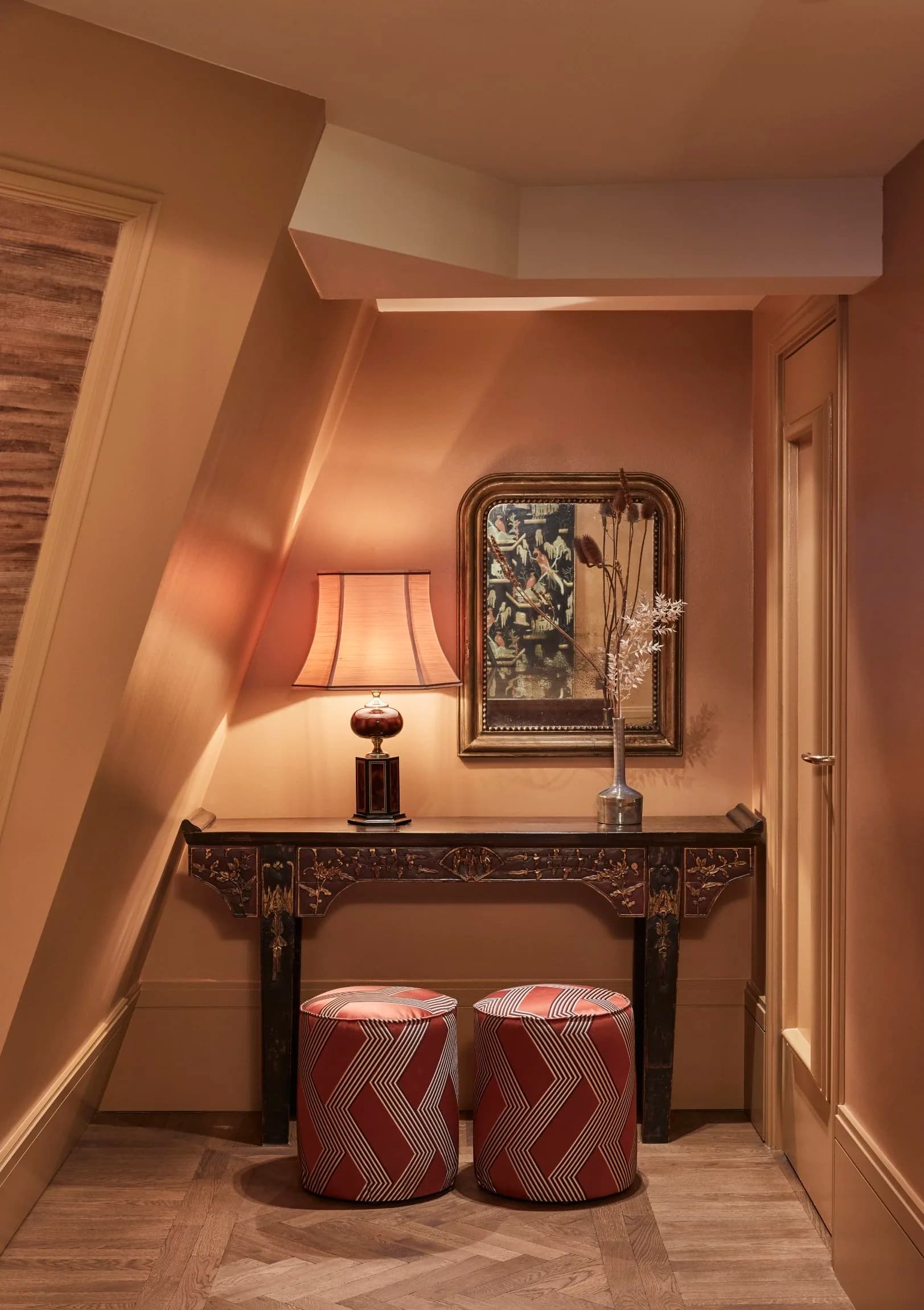 two cylindrical stools in front of a table in a hallway