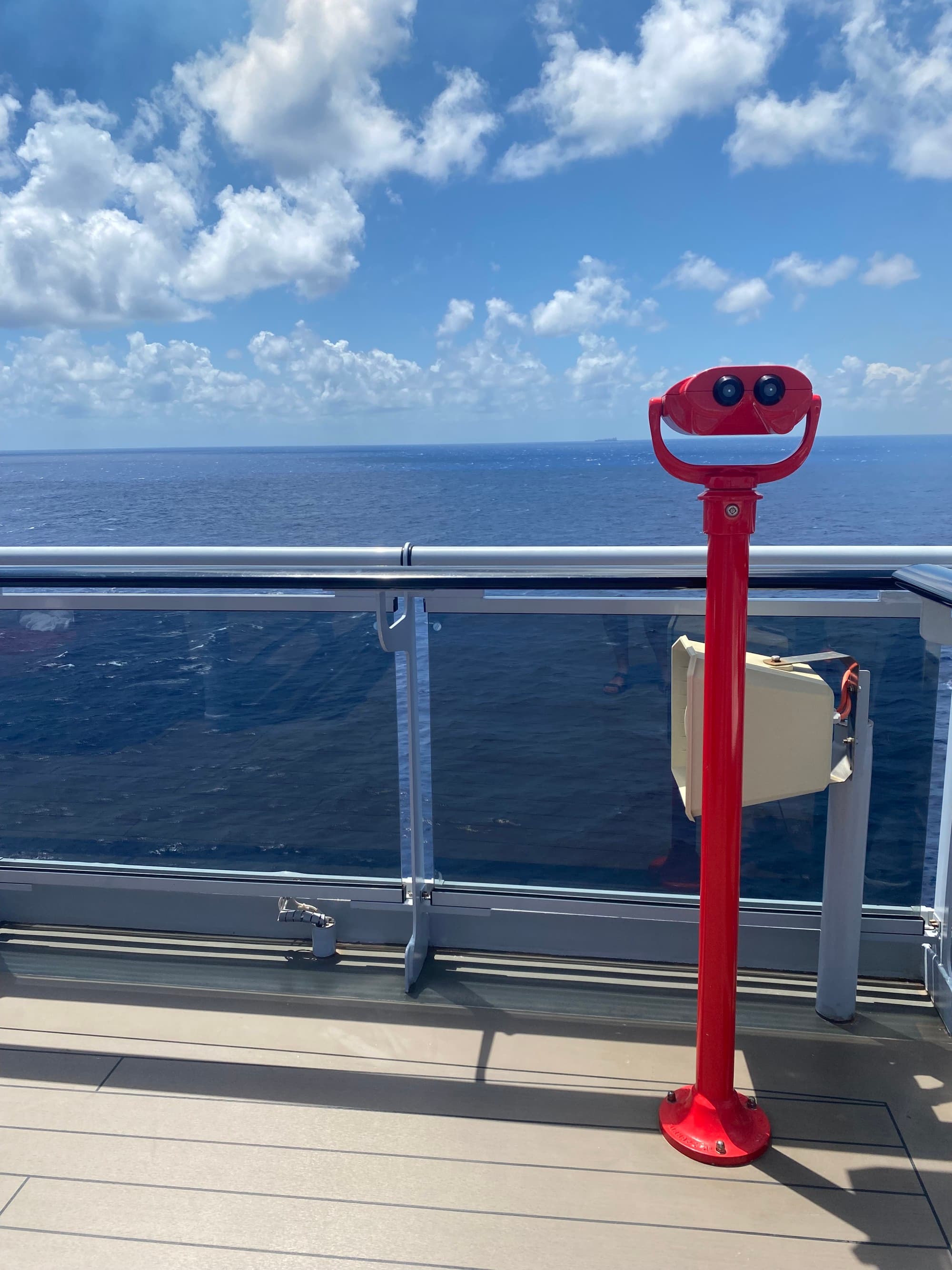 A binocular outlook over the blue sea from a cruise ship deck.