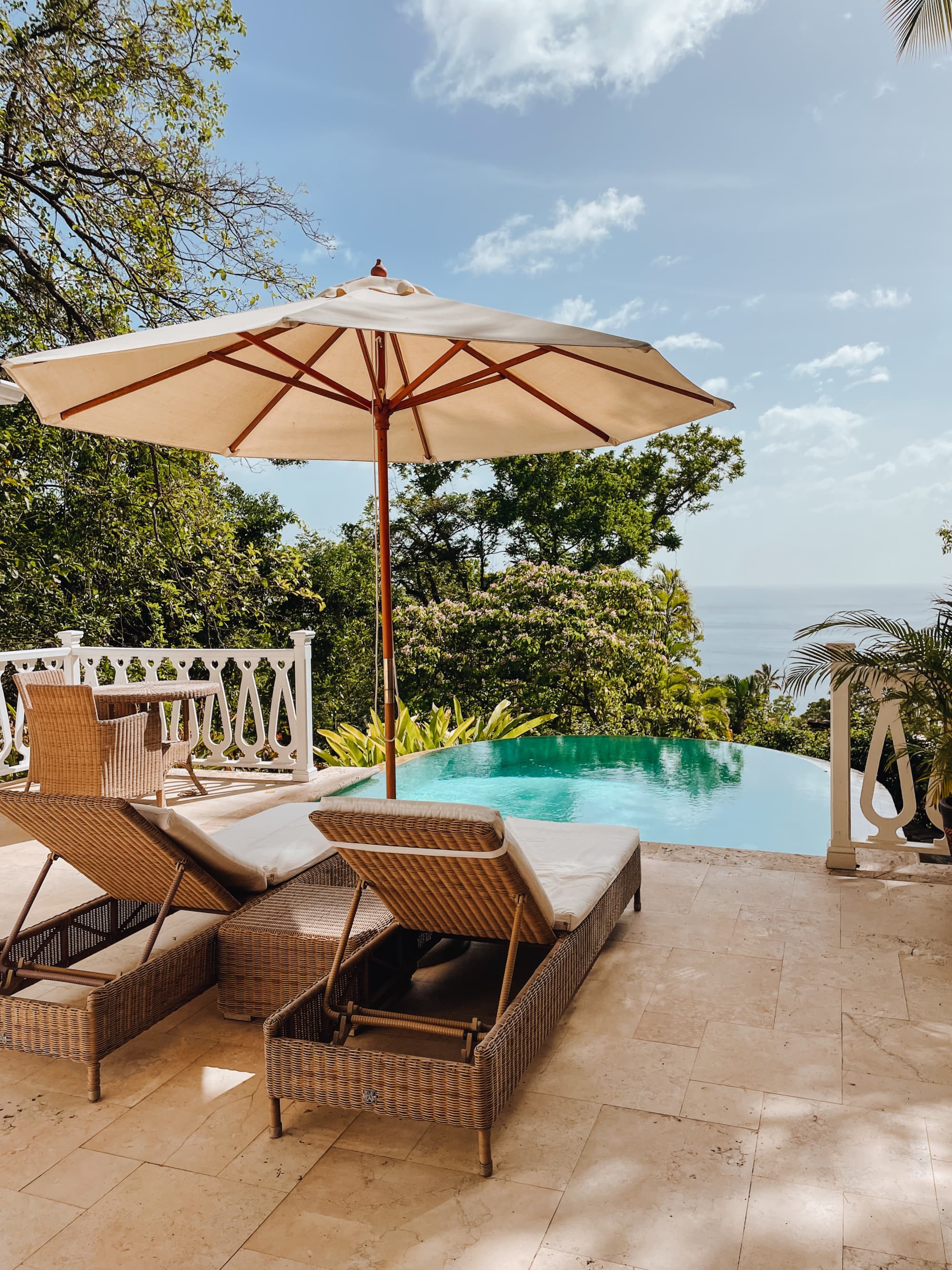 Two sun loungers next to a pool during the daytime