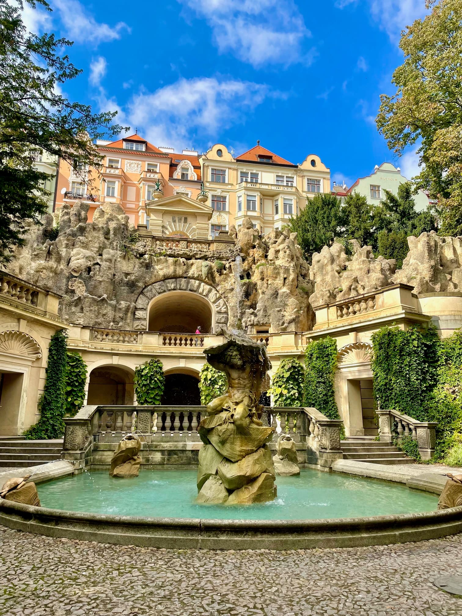 Grotto with beautiful buildings and a fountain - Lauren Baroevich