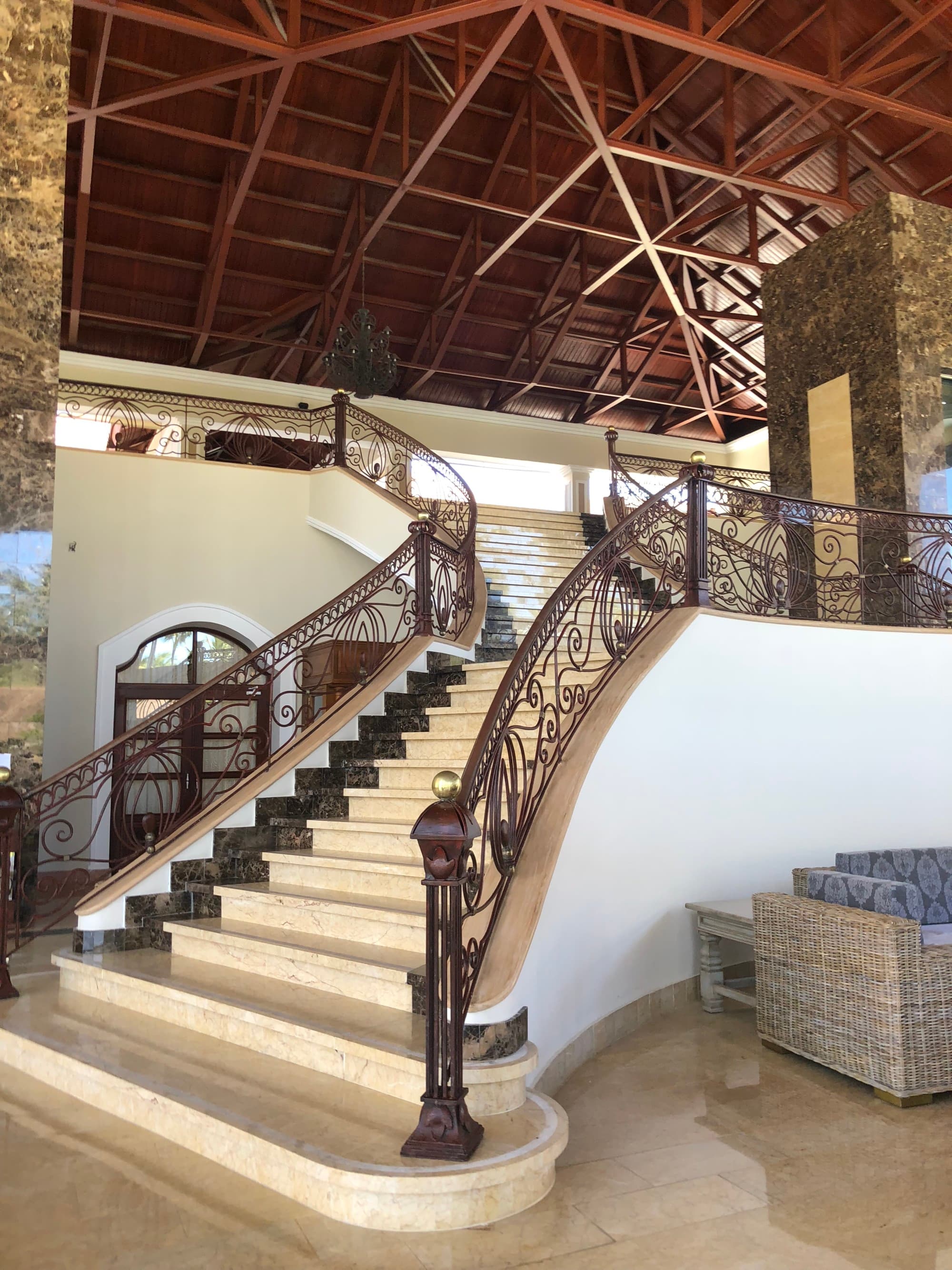 A grand staircase with a wood paneled ceiling above it.