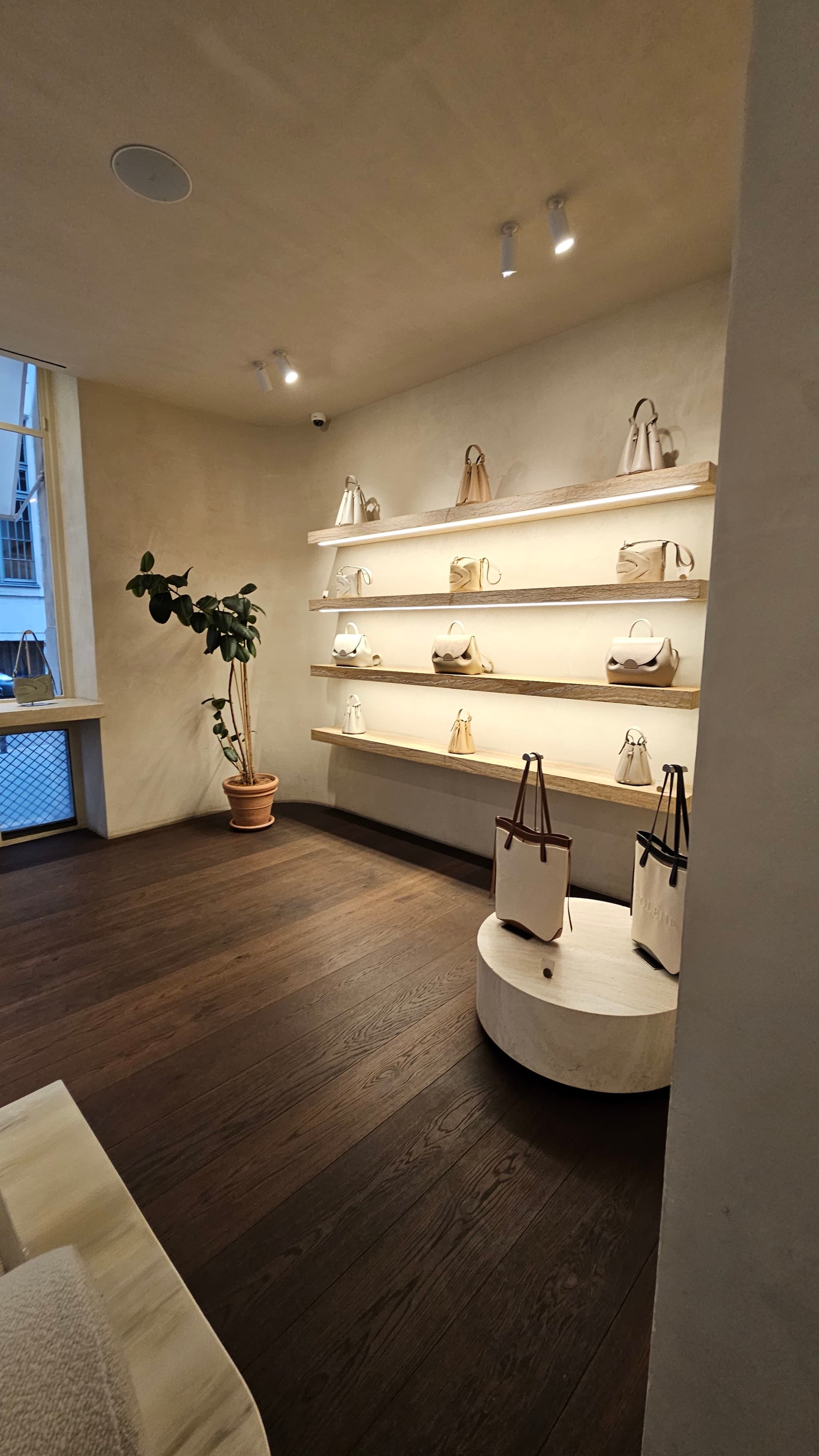 The inside of Polene, with shelves displaying handbags in one of the best shopping areas in Paris.