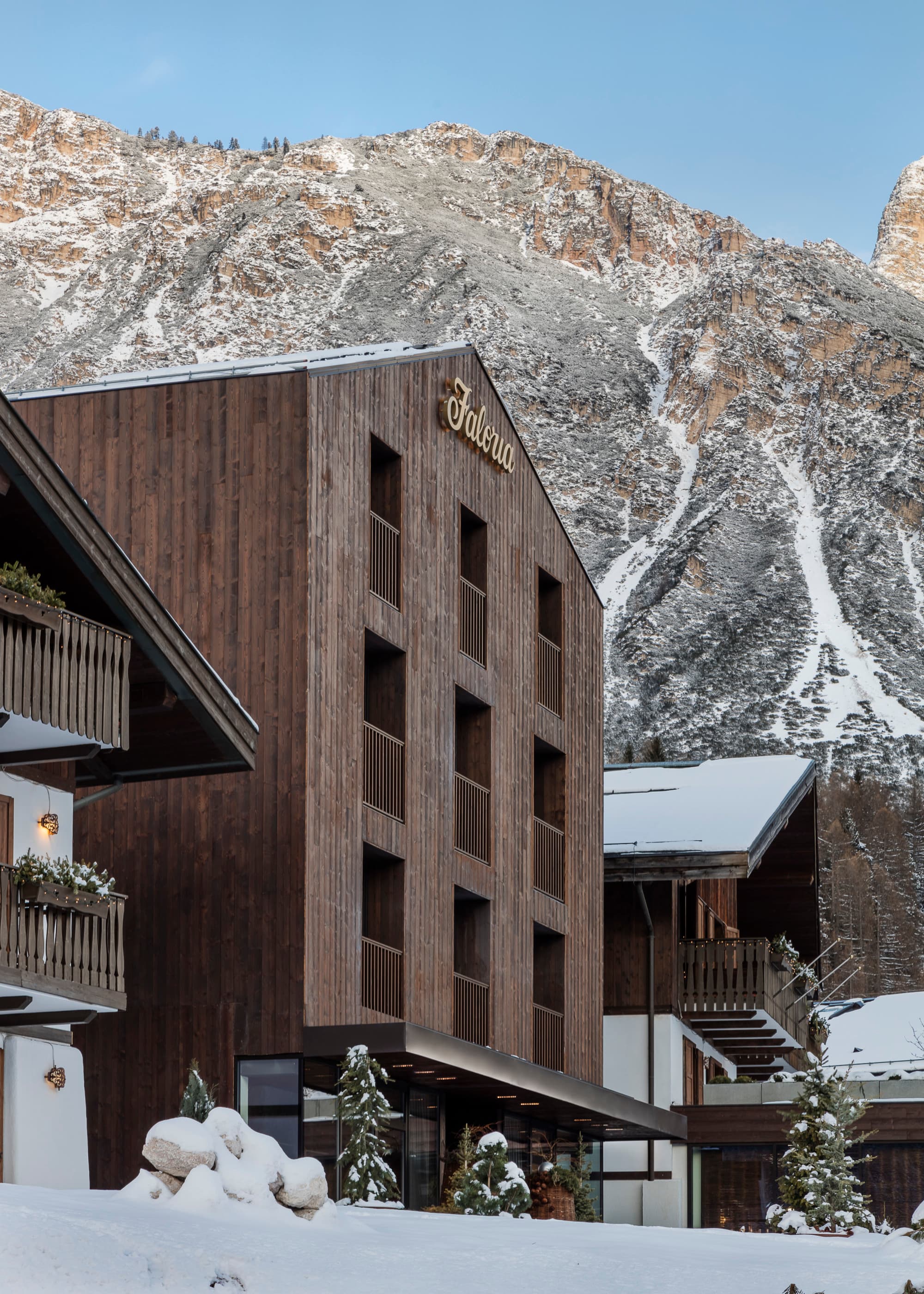 a wooden building in front of a snowy mountain