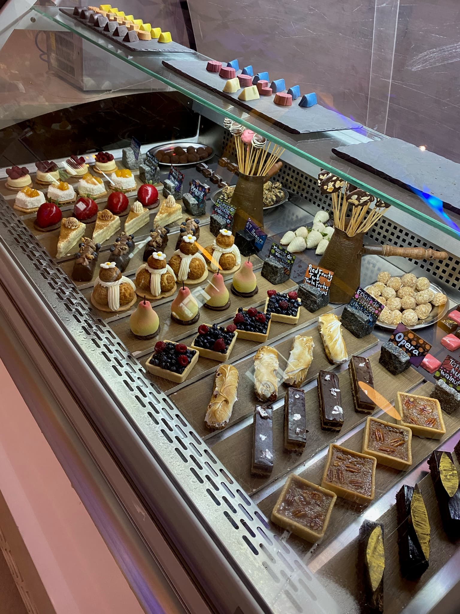 A view of decadent pastries lined up in a display case.