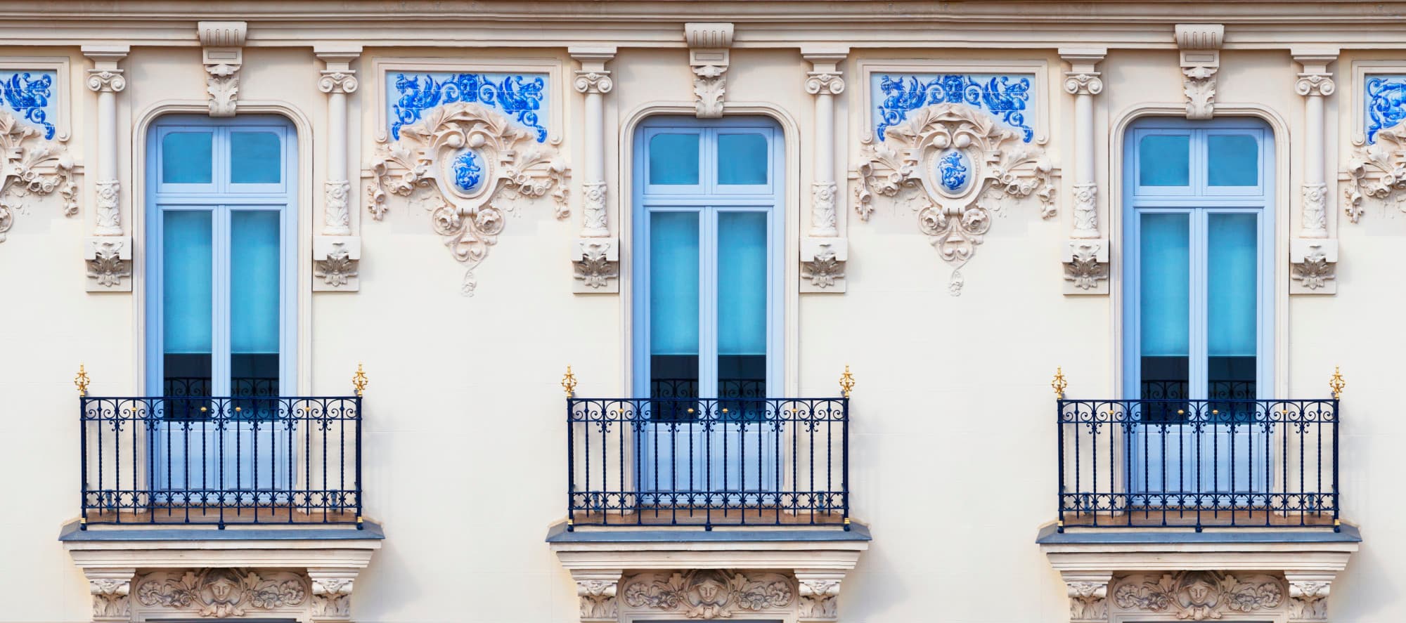 a blue window on an ornate cream-colored building
