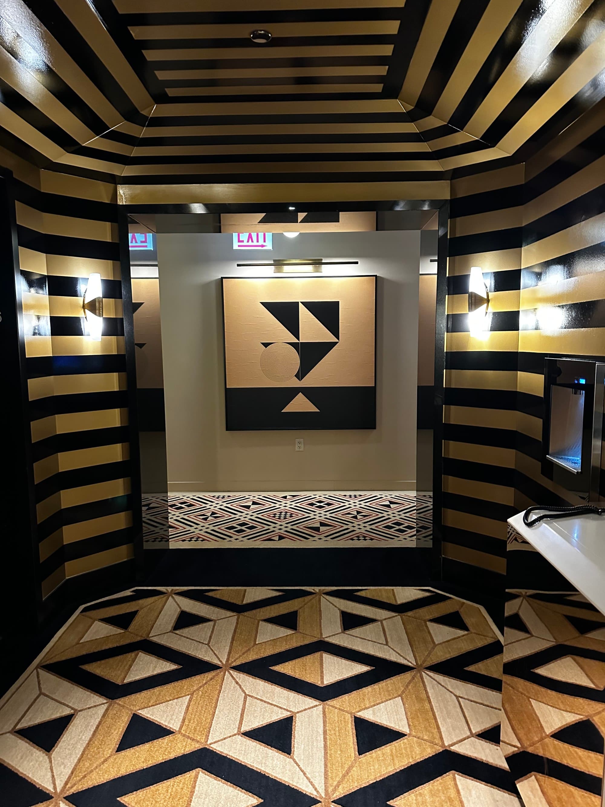 A hotel hallway with patterned floor, ceiling and walls