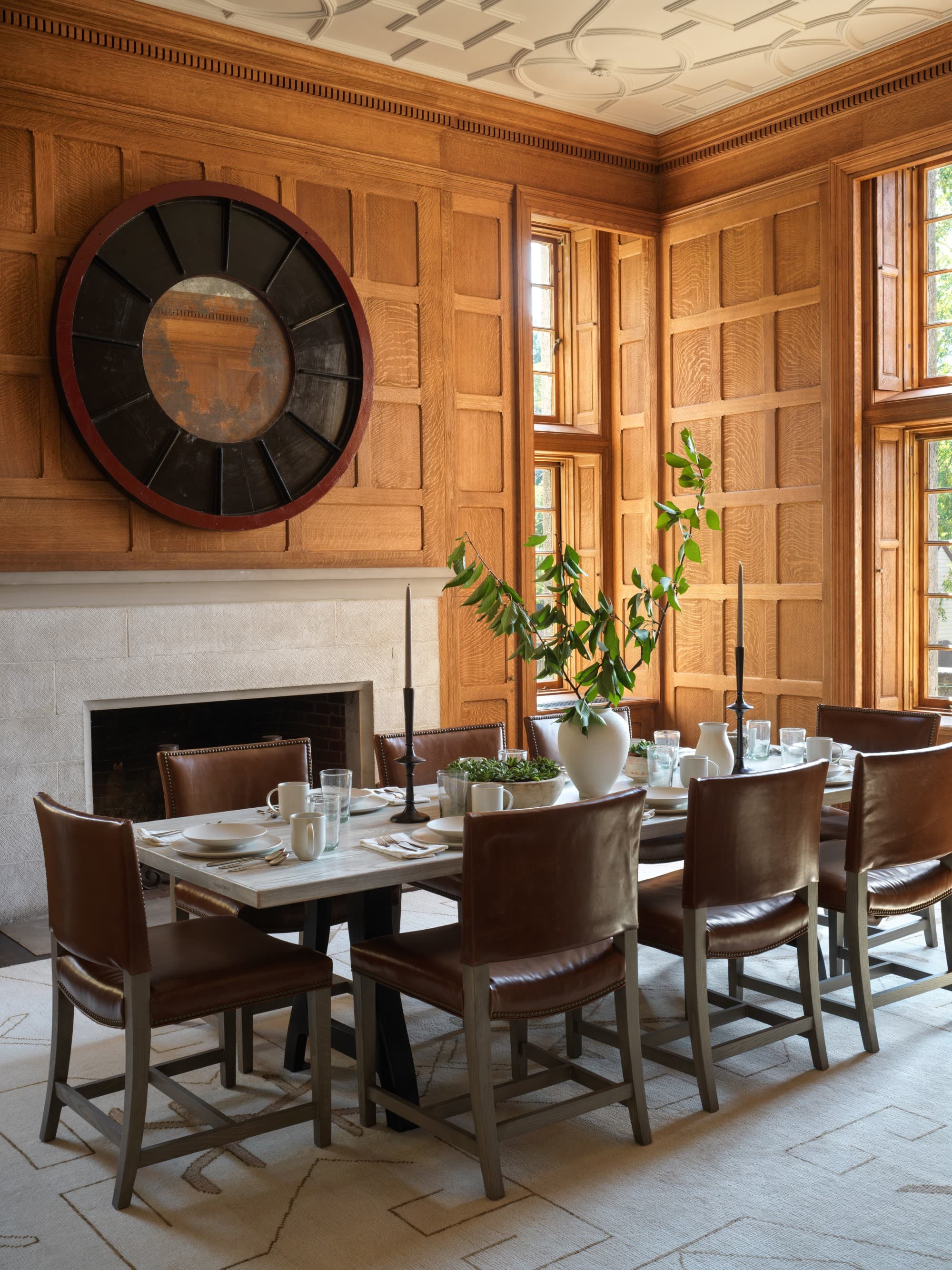 a long wooden table near a white fireplace