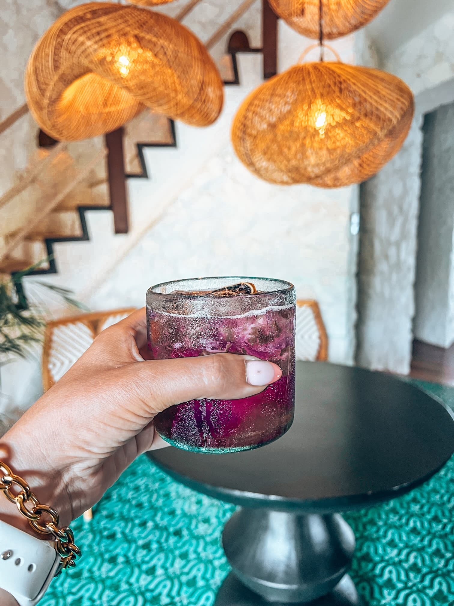 A hand holding a purple drink