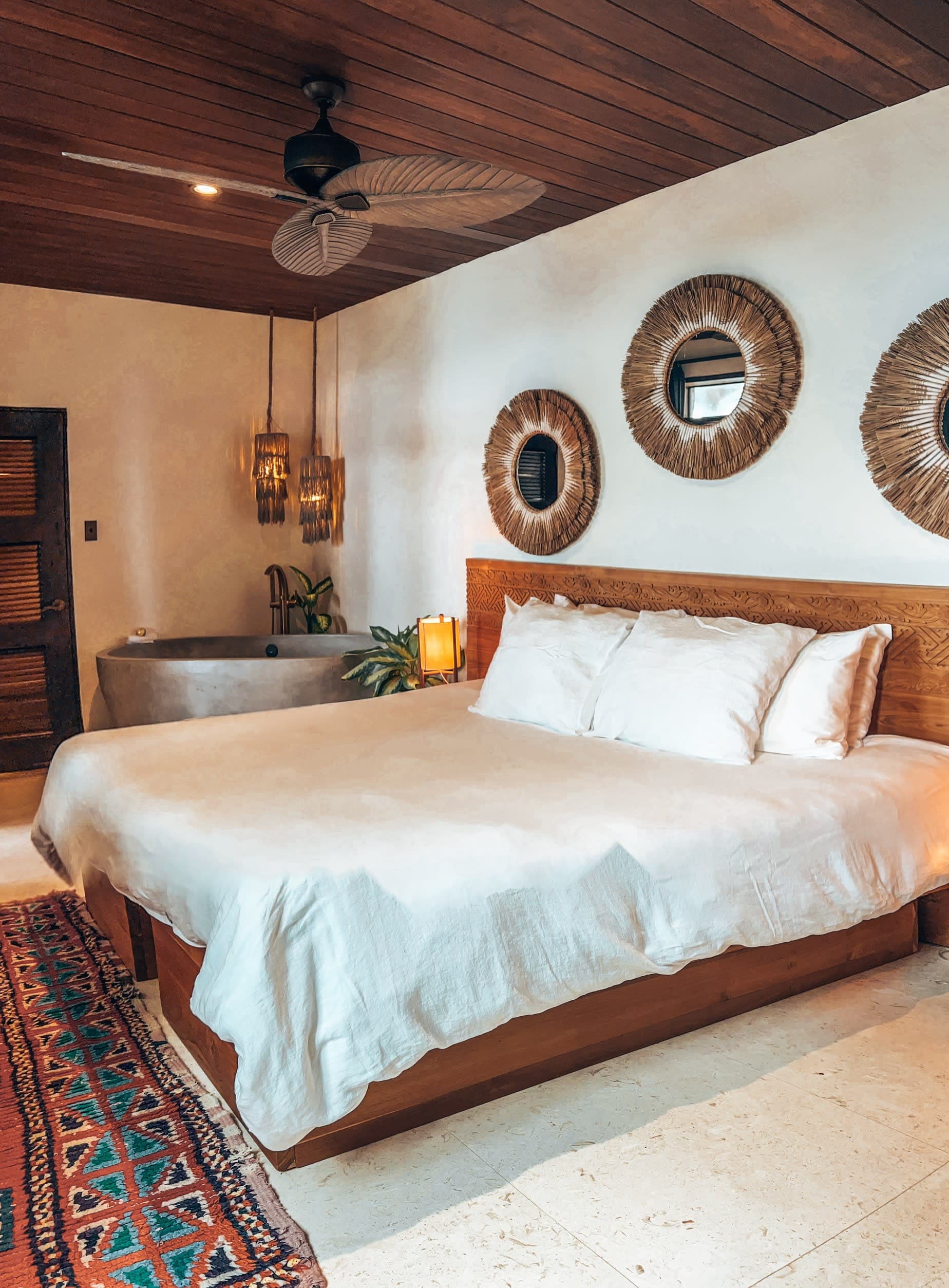 A large bed with white sheets in a hotel room