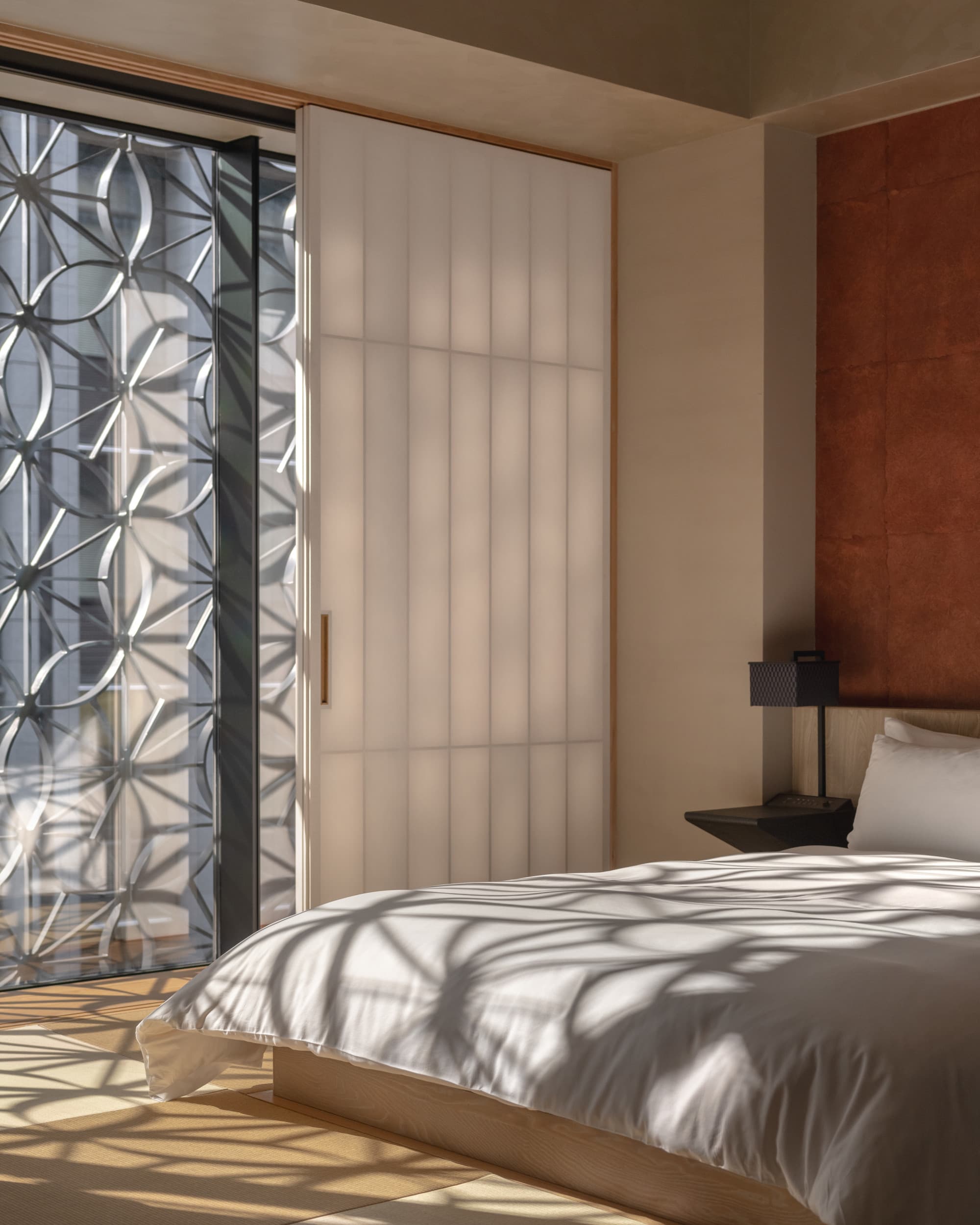 a sleek minimalist bedroom with a white bed and floor-to-ceiling wnindows