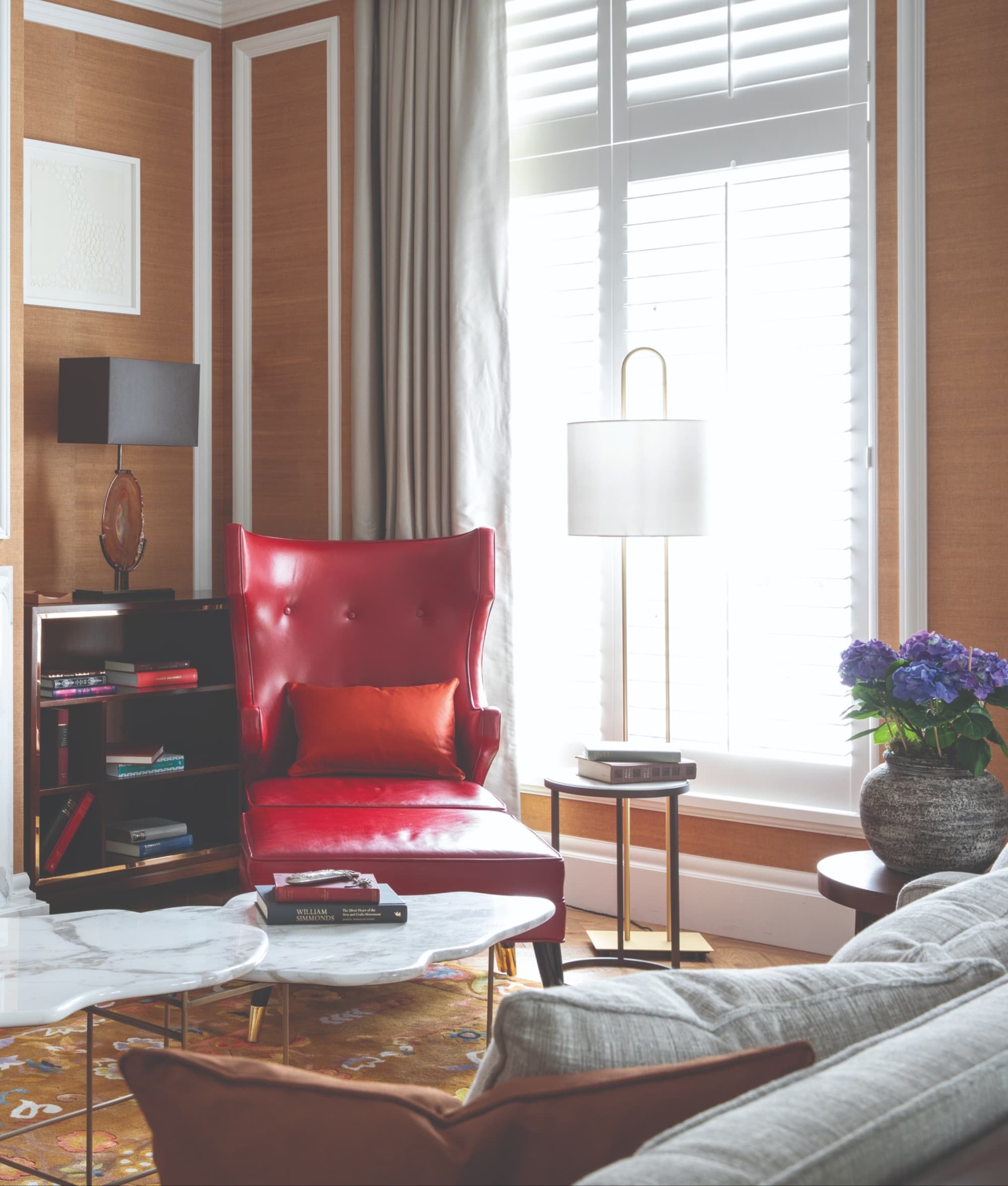 a red leather chair near a fireplace in a corner of a living room