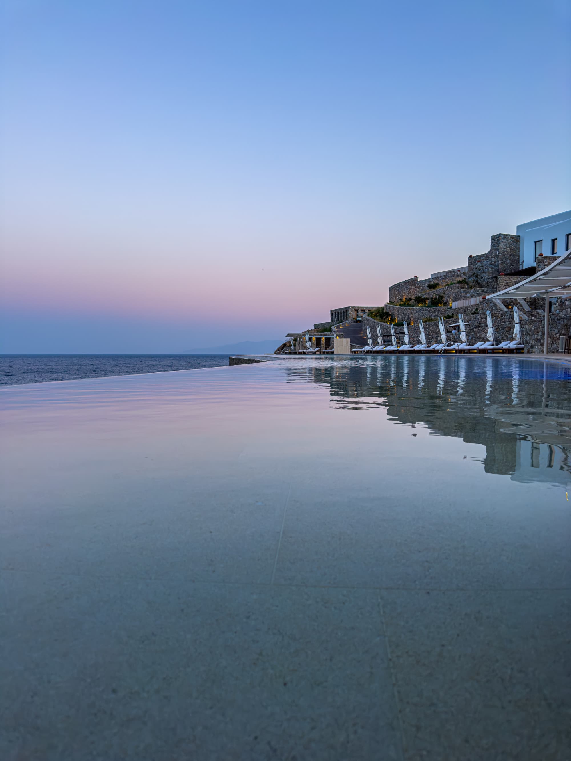 a resort overlooking a long infinity pool at night