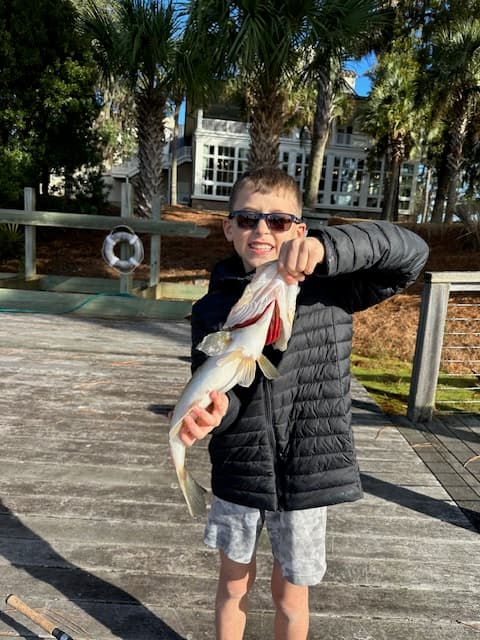 The kid holding a fish
