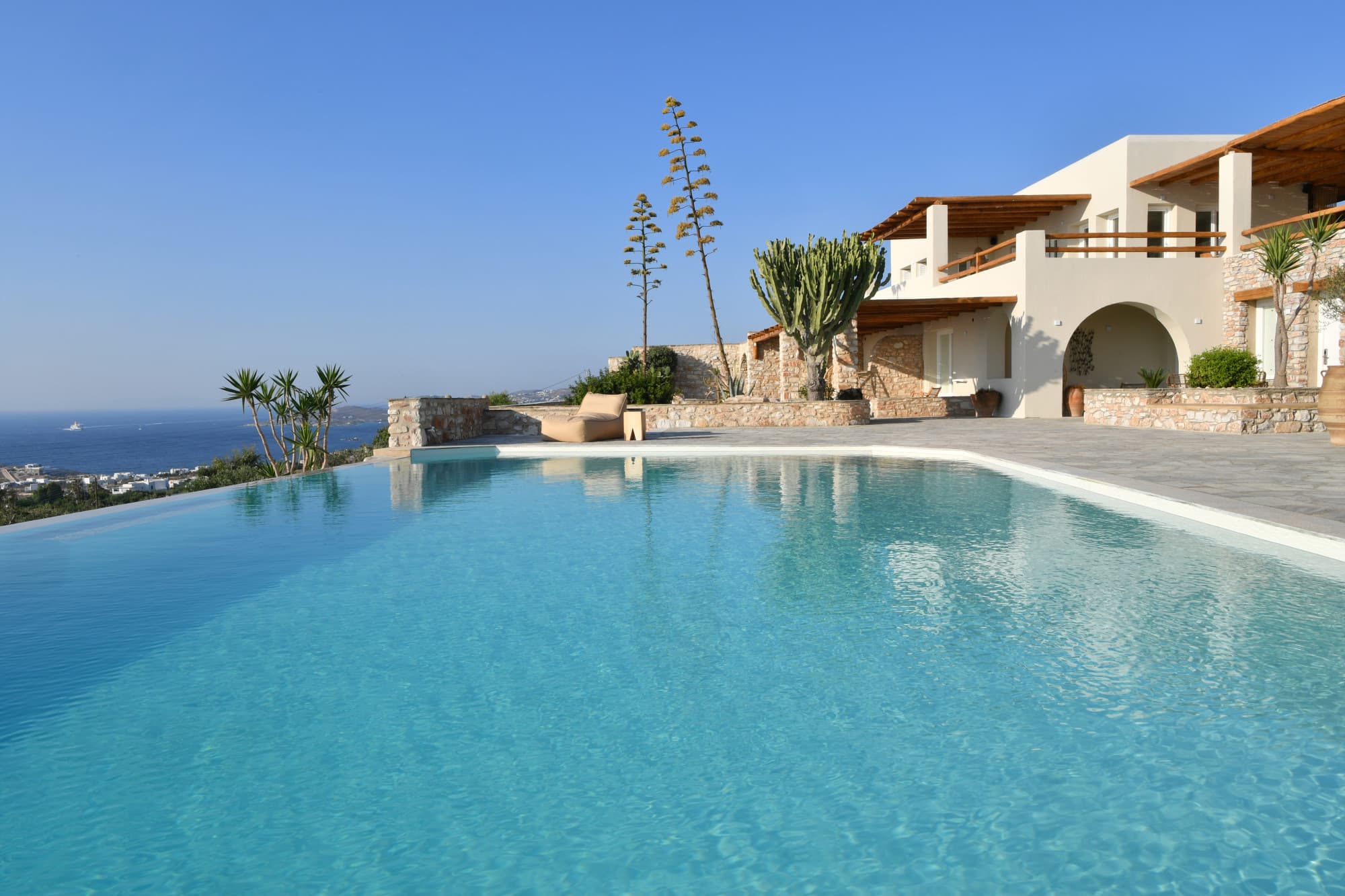 sleek pool and white villa with an ocean view