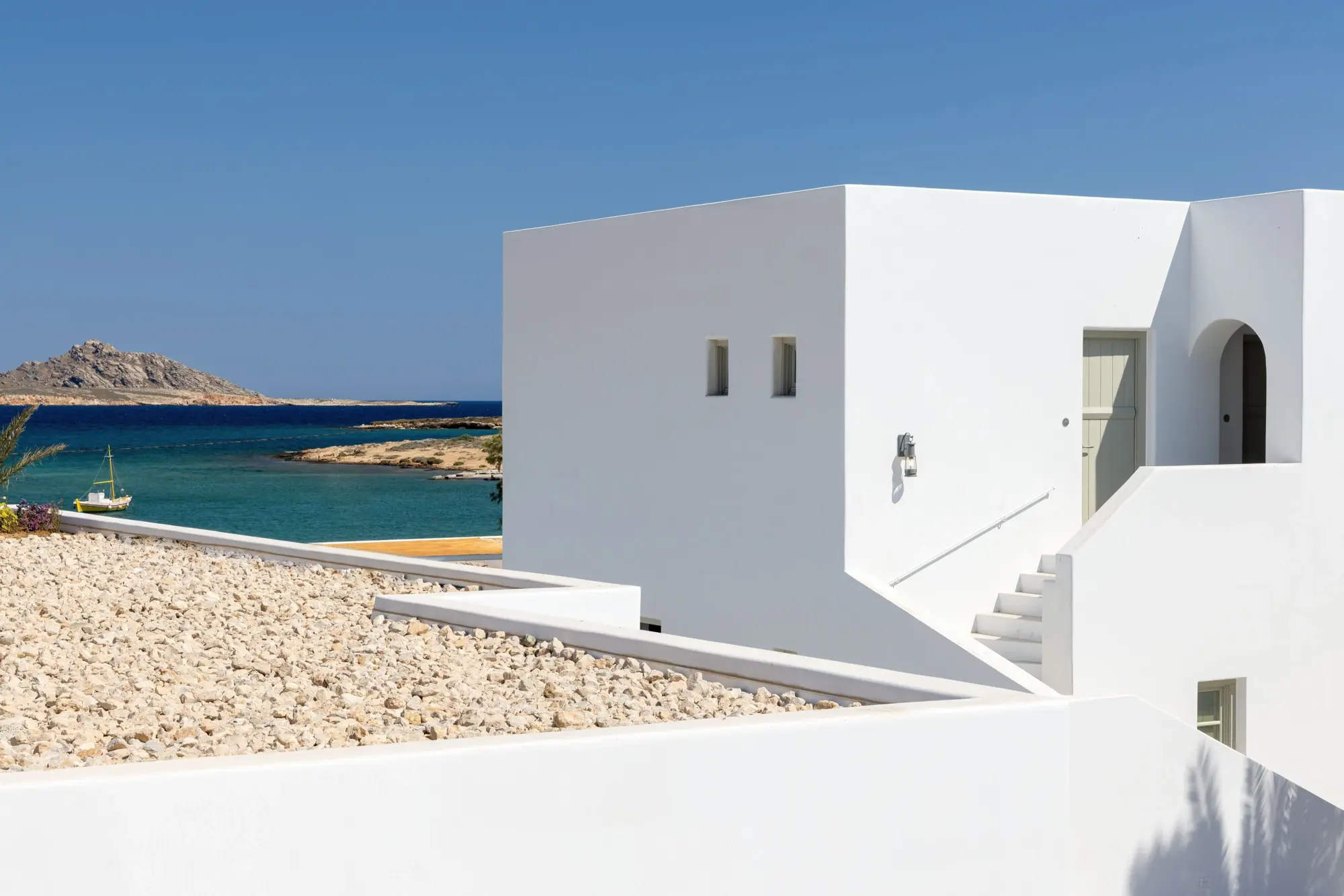 a white cube building on a sunny beach