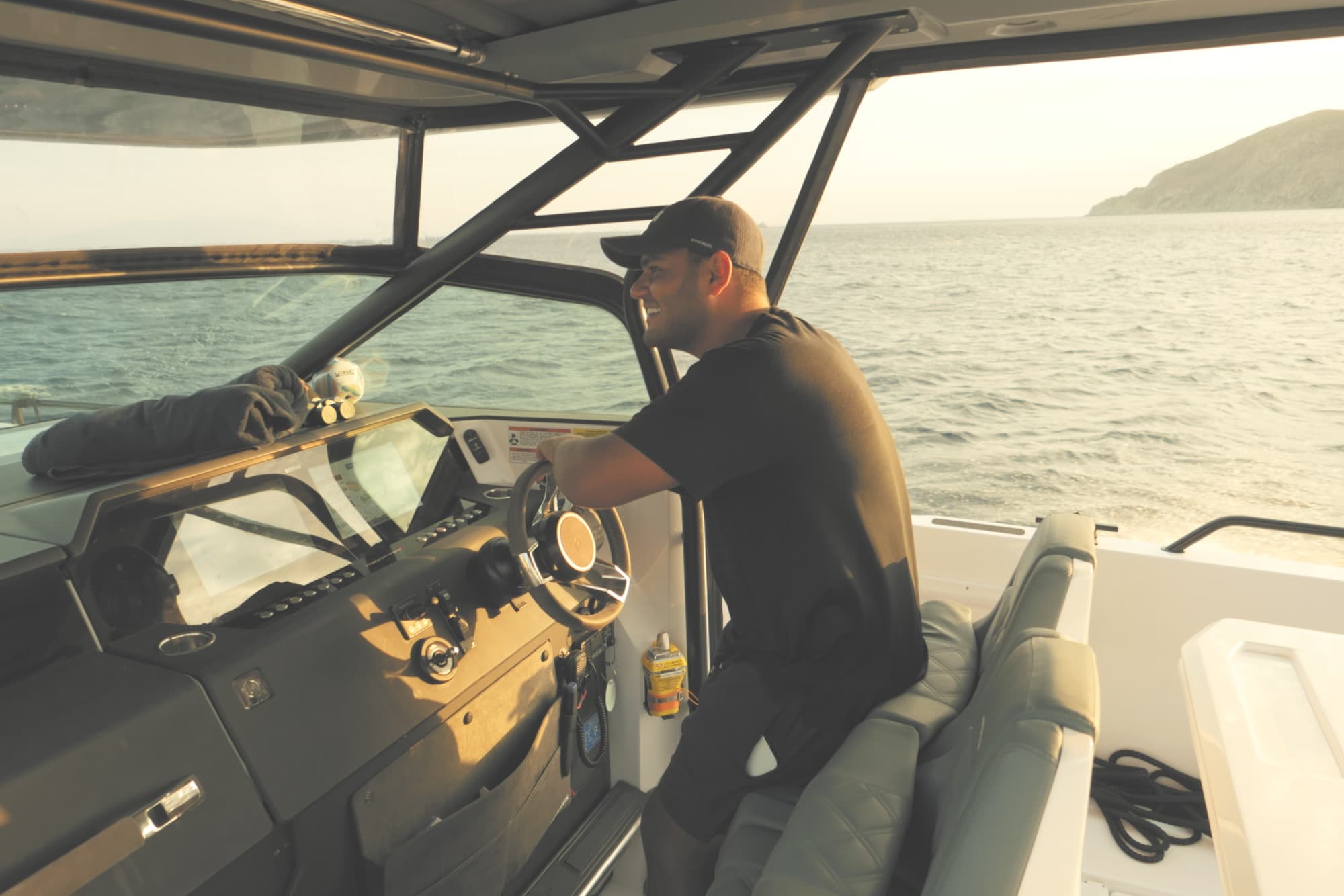 a man in a hat and tee shirt drives a small boat