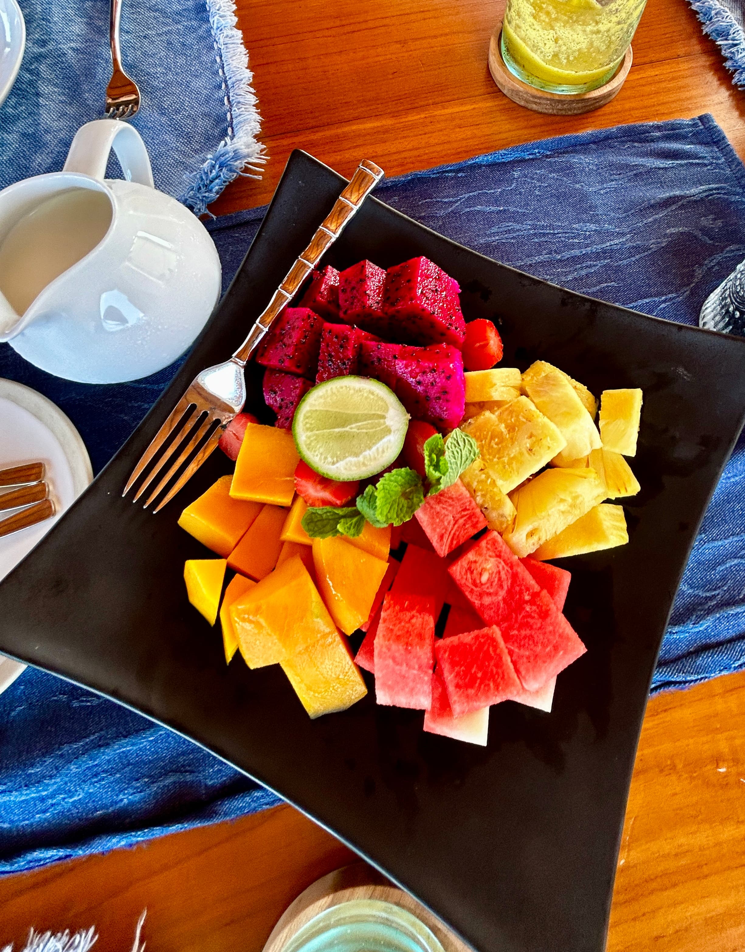 A plate of fresh fruit with a morning juice.