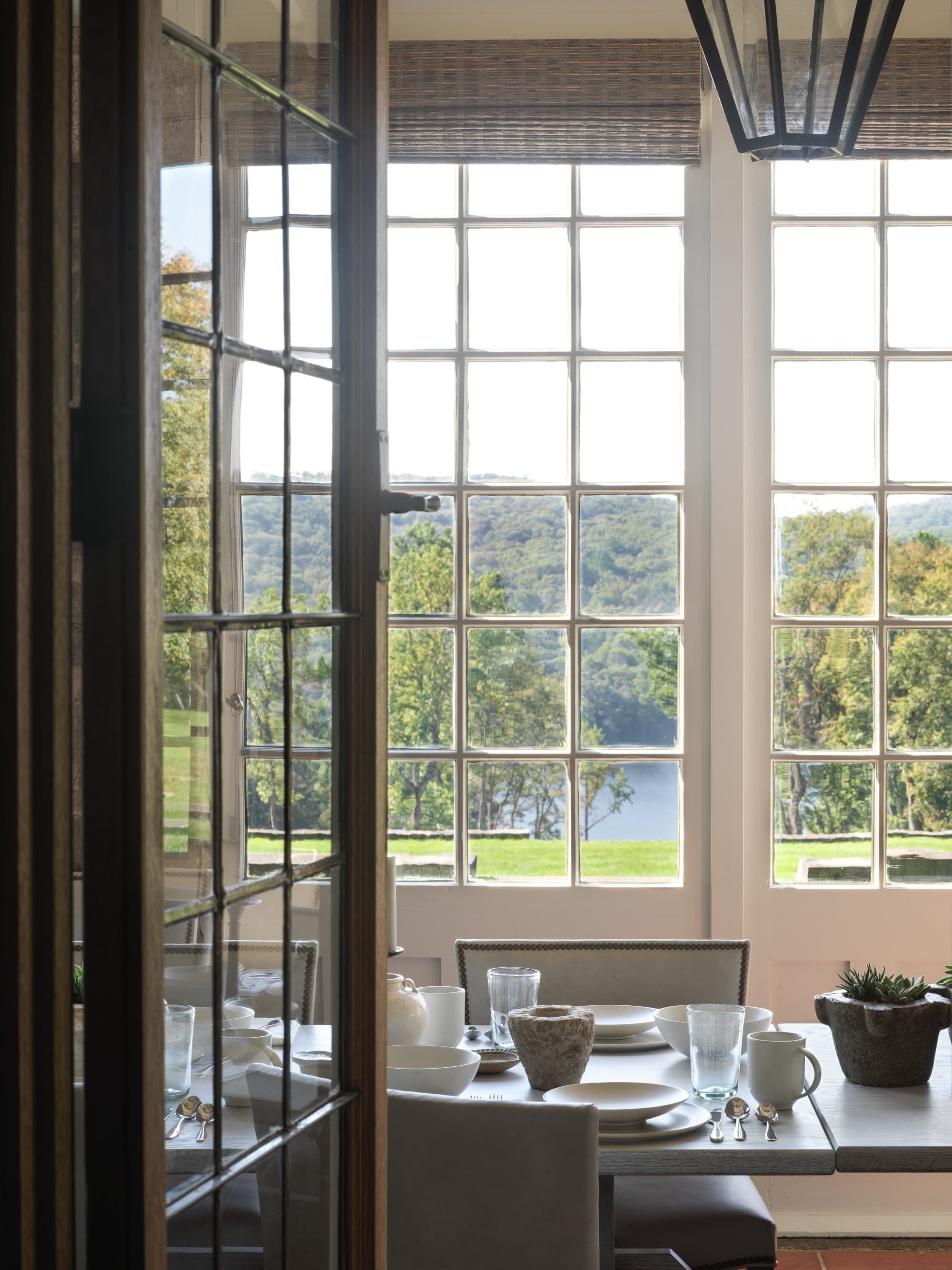 a set table near a window overlooking the countryside