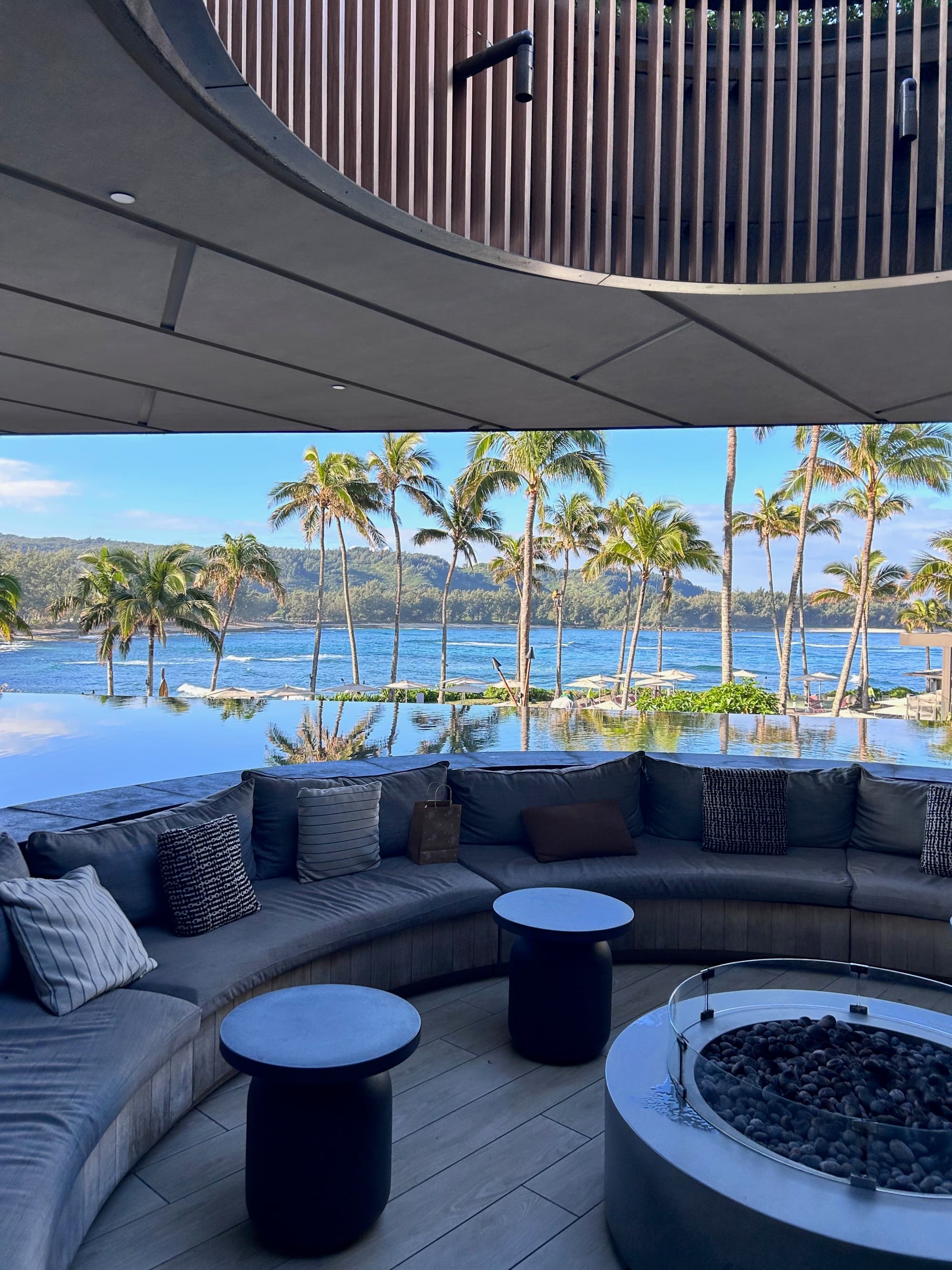 A round seating area next to a beach during the daytime