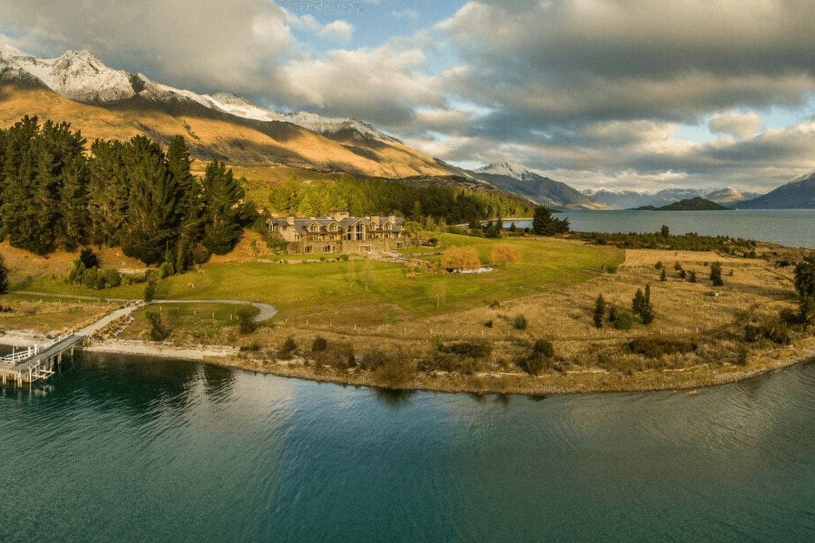 a rustic alpine lodge on a gassy expanse overlooking a lake