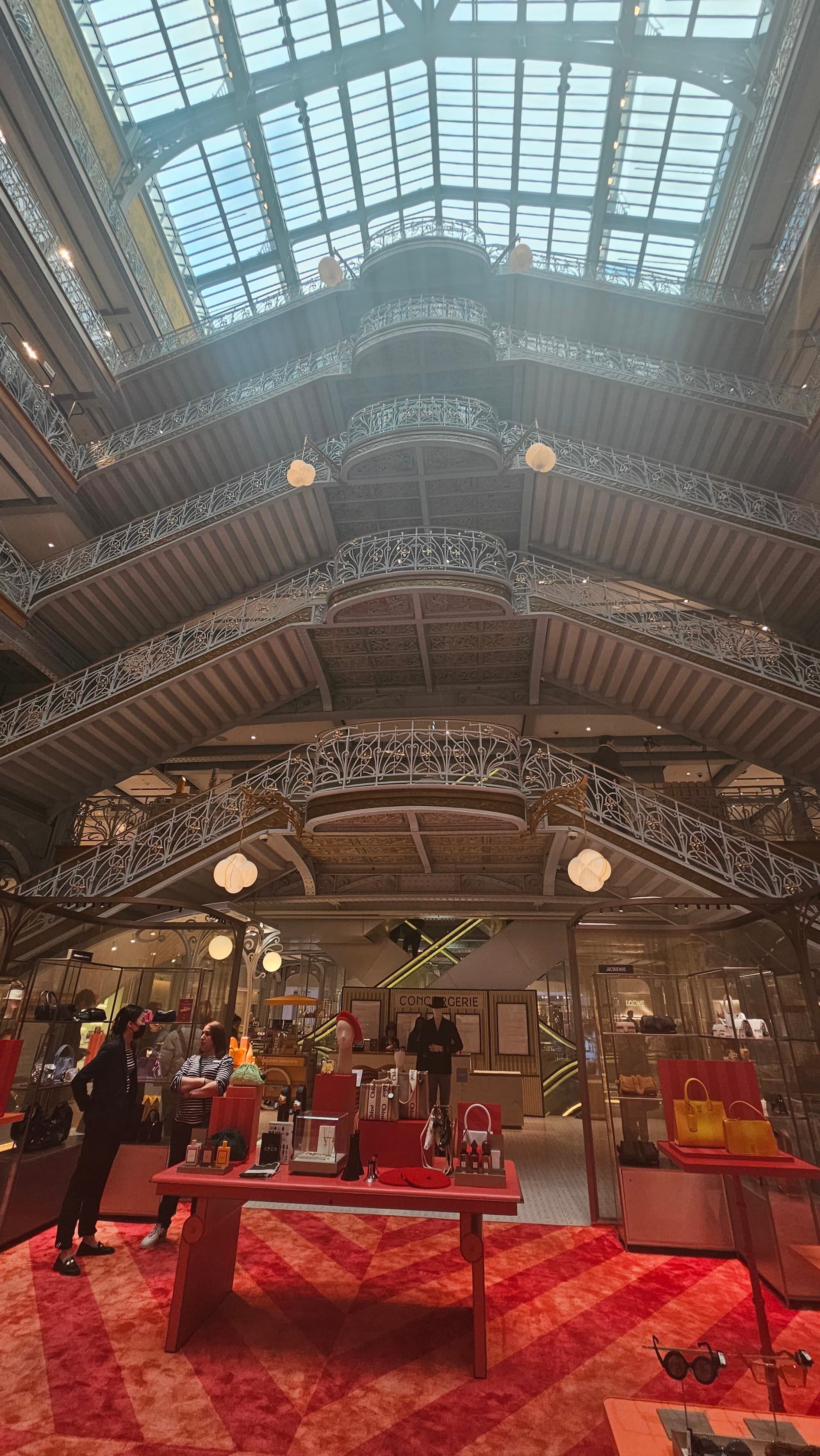 A department store with red carpet and glass ceiling in one of the best shopping areas in Paris.