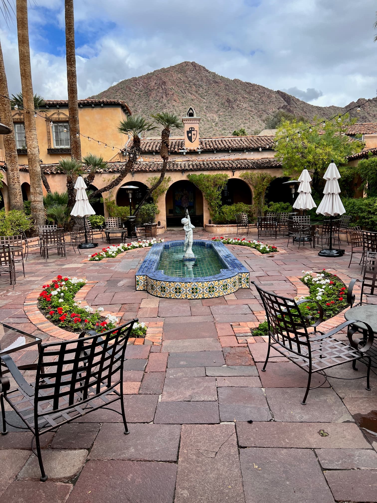 An outside scourtyard with, benches, a pond and beautiful foliage