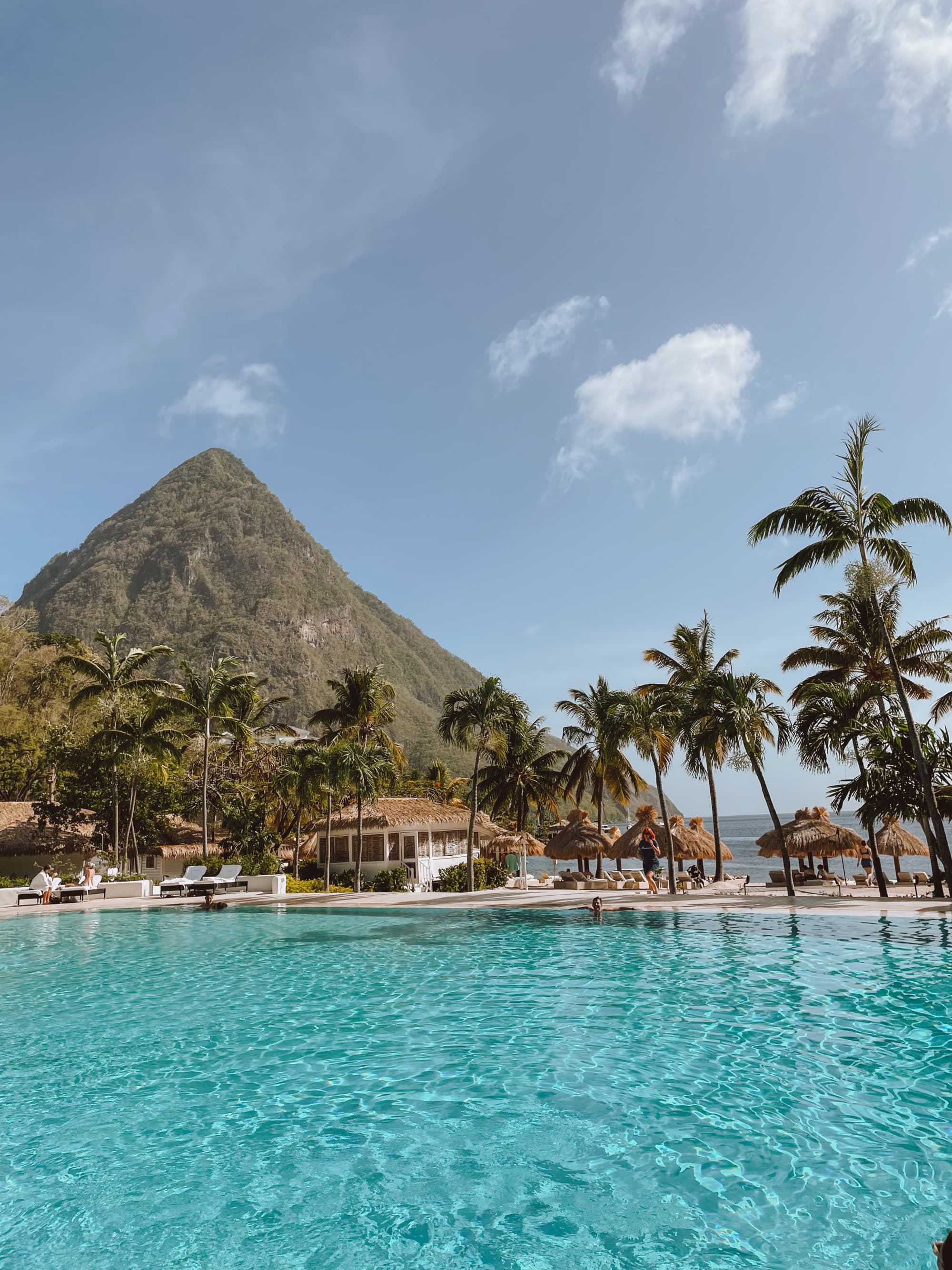 A pool area during the daytime with a mountain in the distance