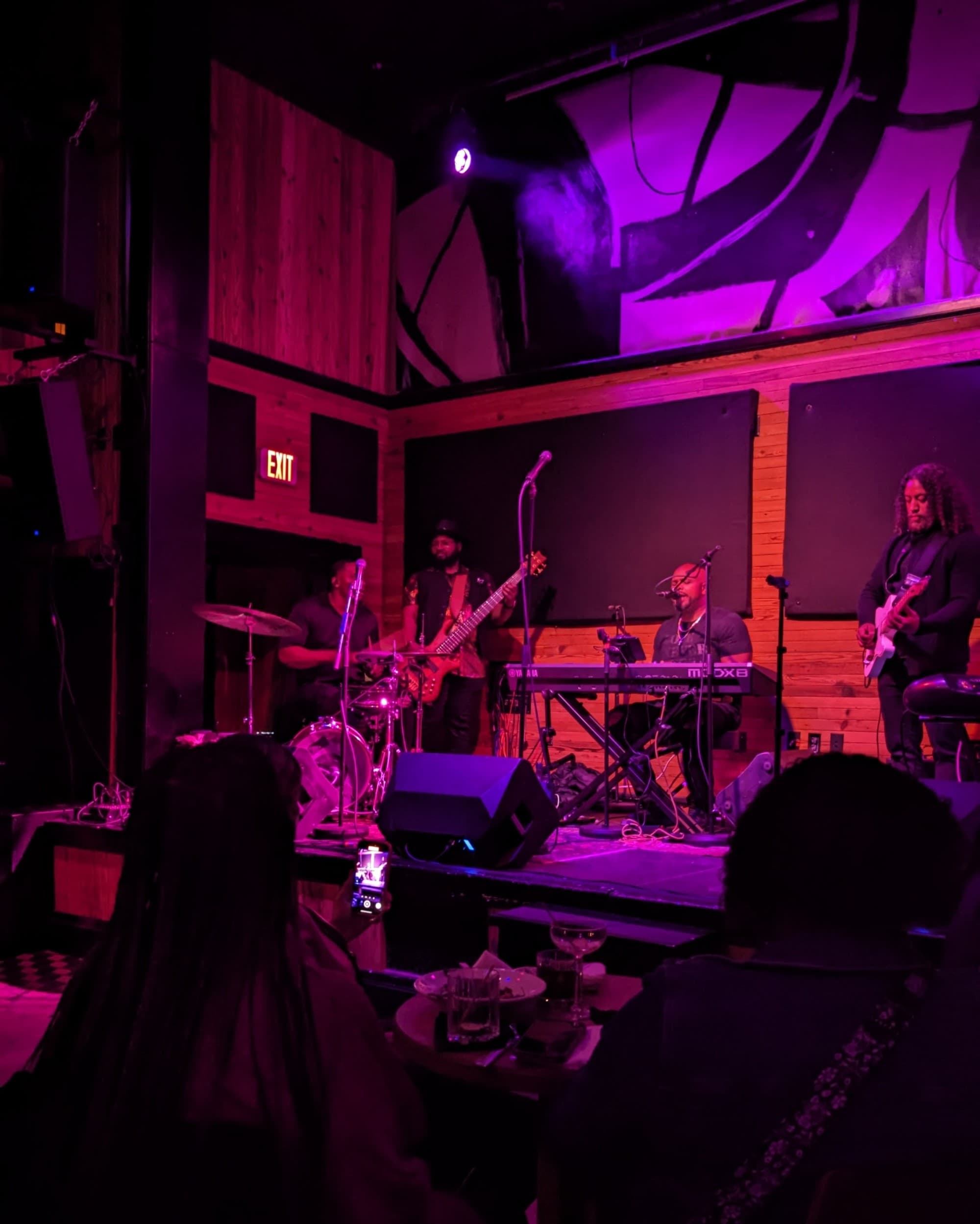 A band on stage in a dimly-lit room