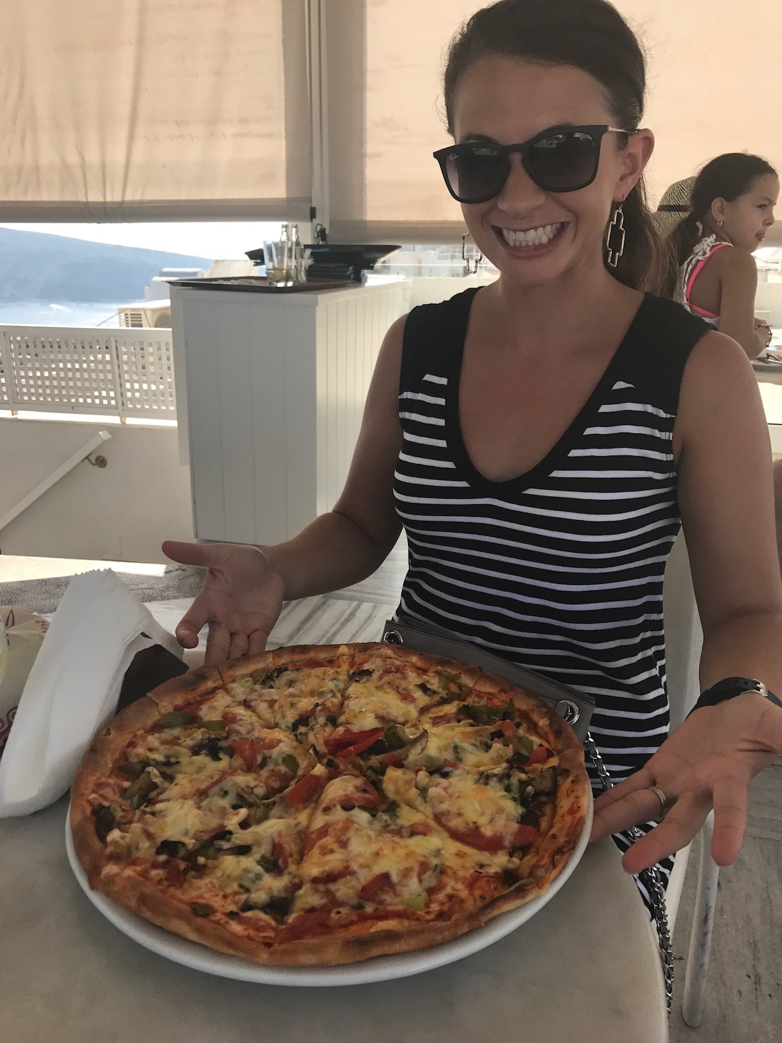 Travel advisor Andrea posing with pizza in a restaurant