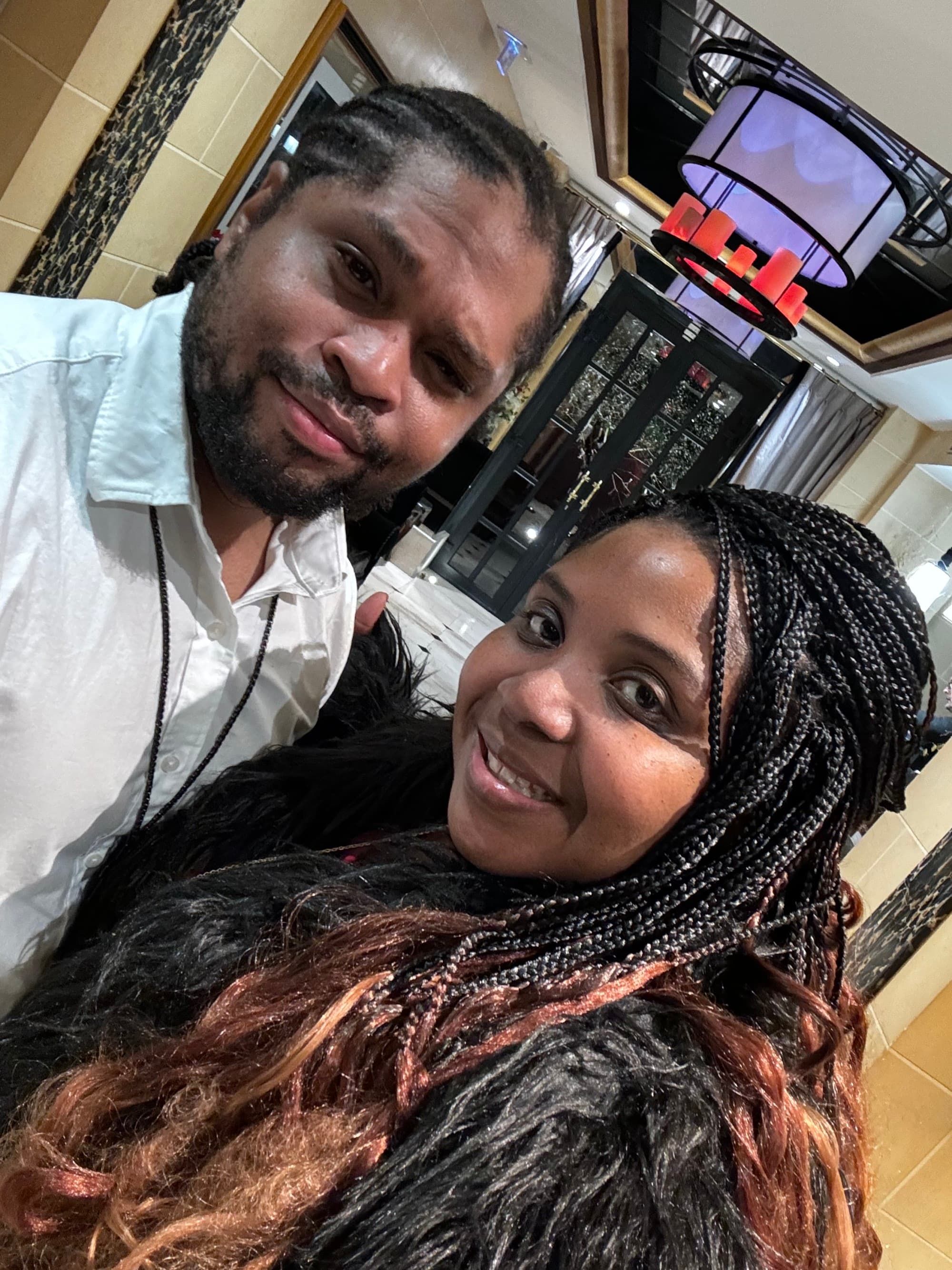 Selfie of a couple in a hotel hallway with black and gold accents