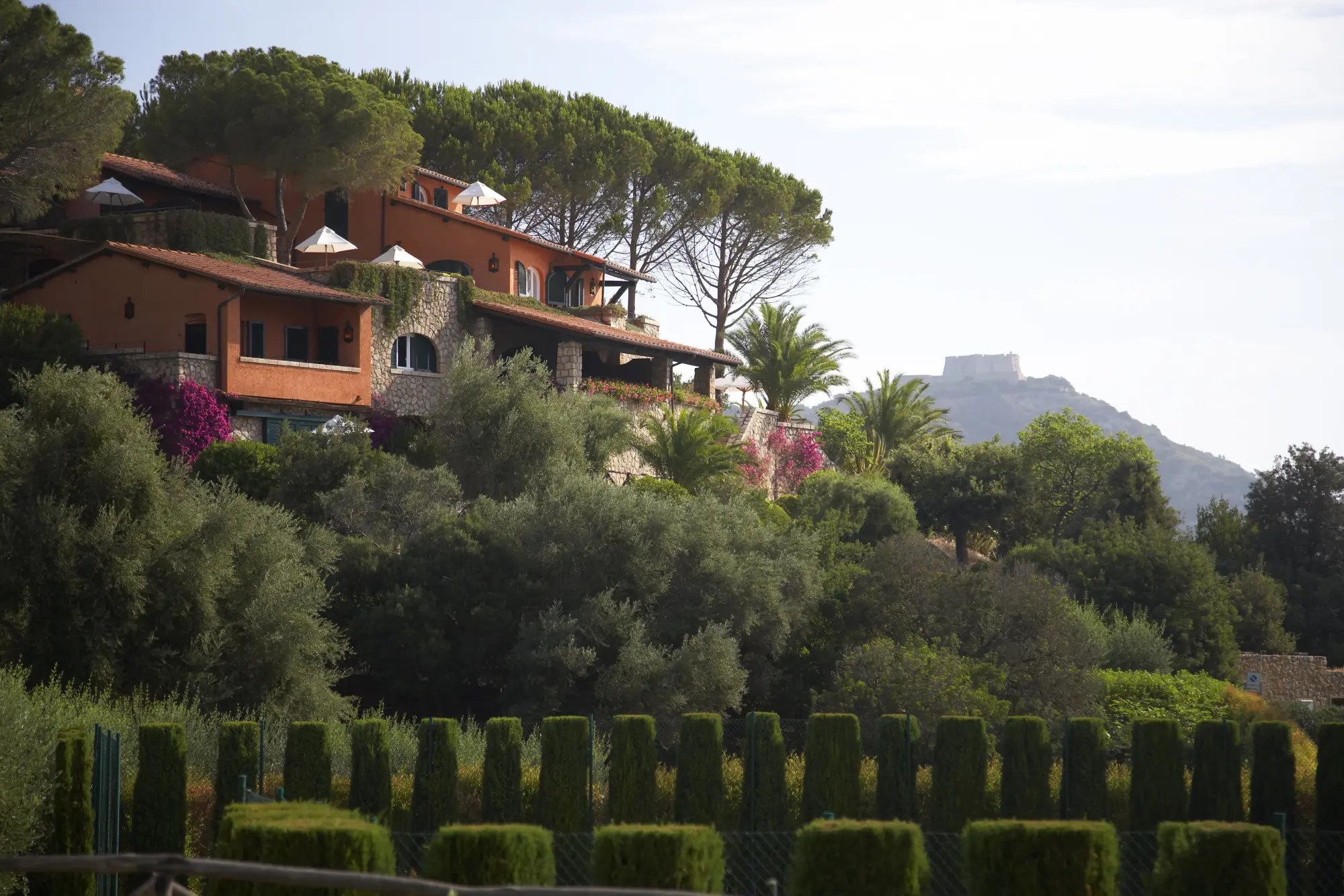 a red Italian villa on a lush hill