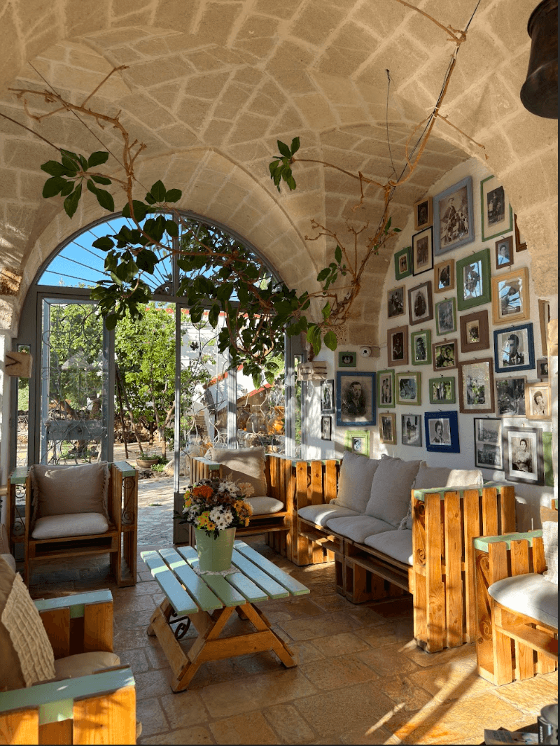 The lounge area of the villa with wooden furniture, a domed ceiling and black and white photographs covering one of the walls.