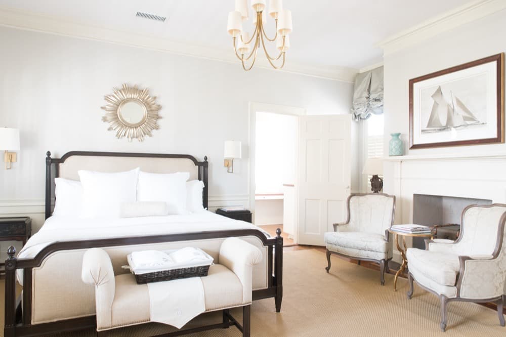 white hotel room with gold-colored chandelier