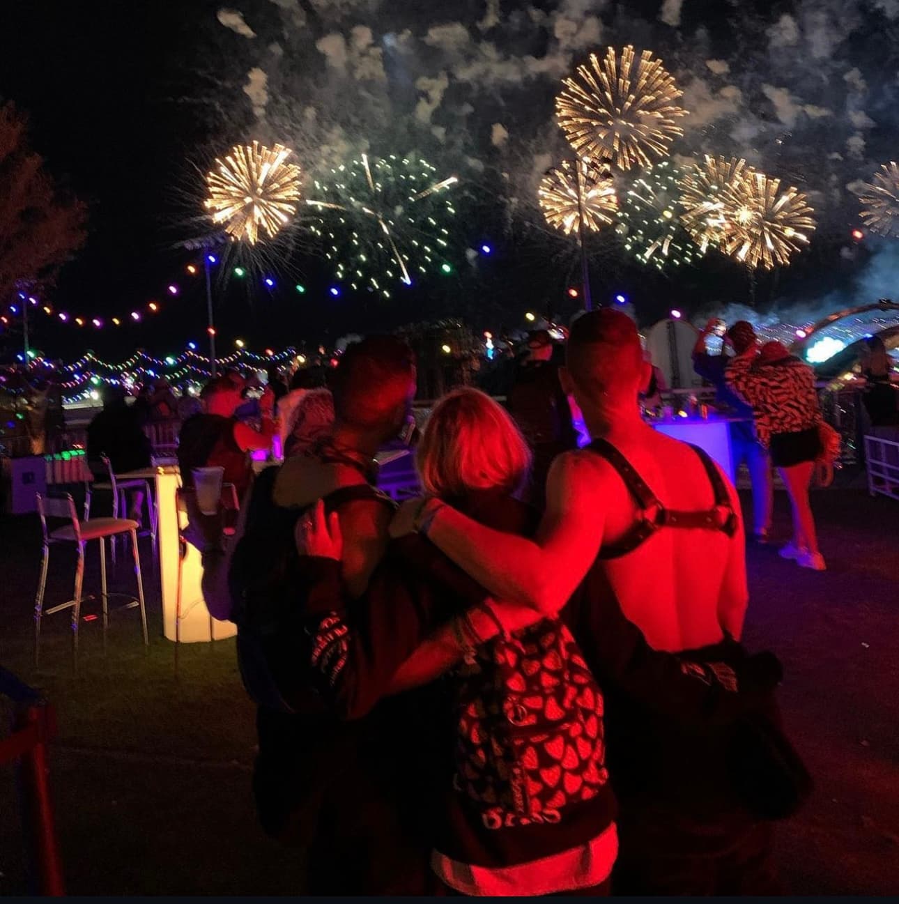 A picture of two people in a crowd watching a fireworks display at an outdoor concert in Las Vegas