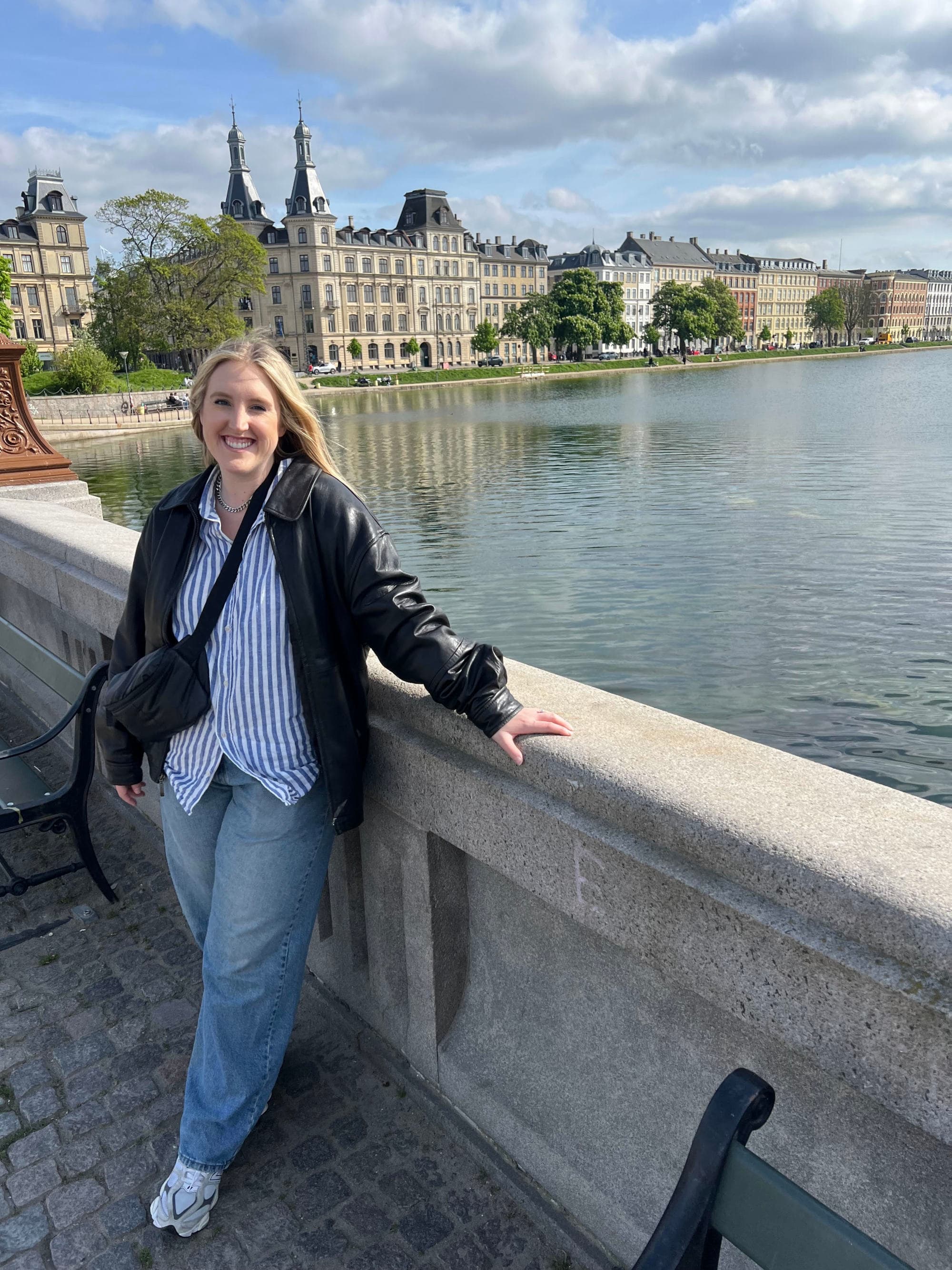 A person posing for a photo on a bridge over the water