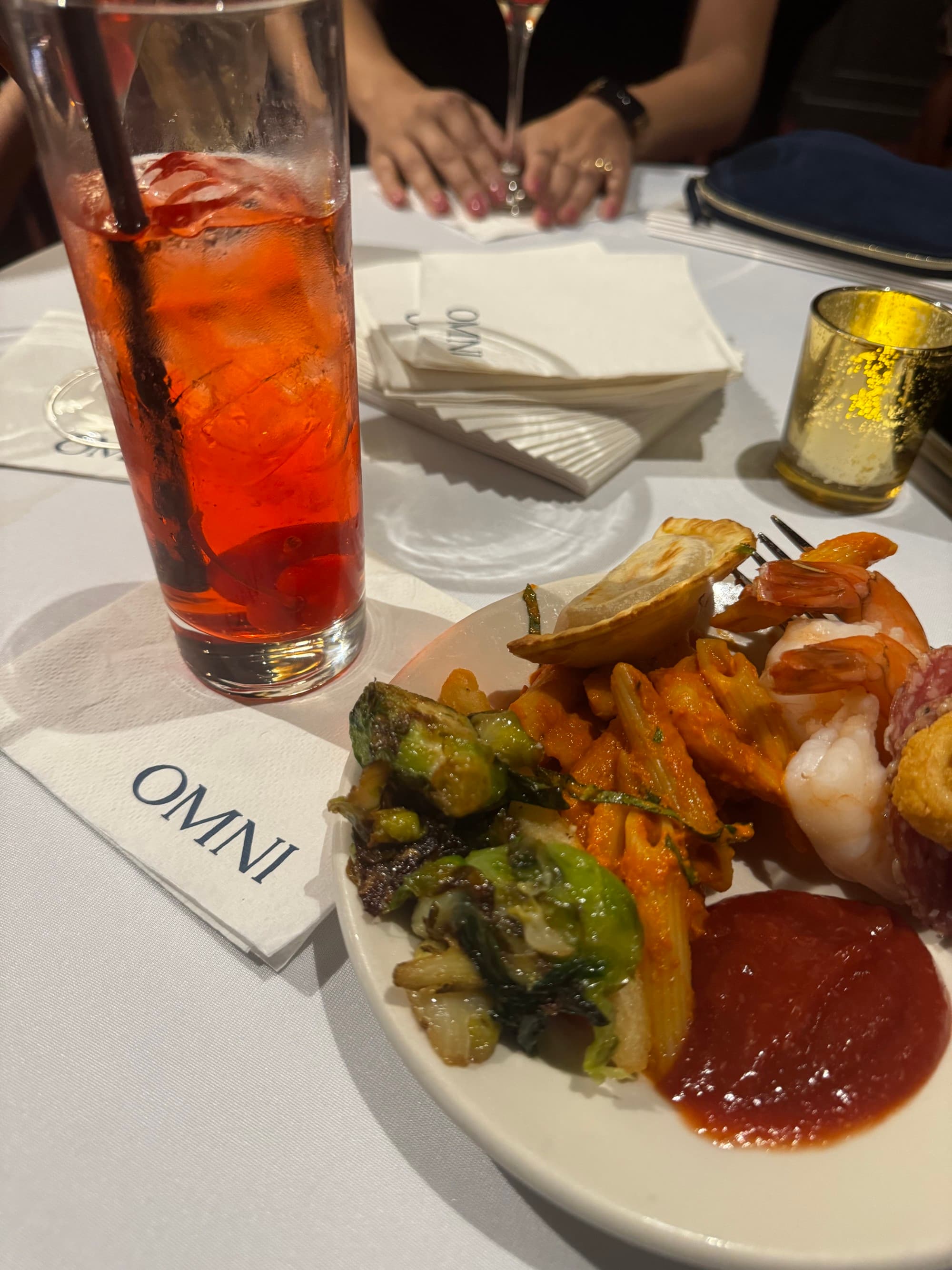 A plate of food and a tall glass of juice on a table