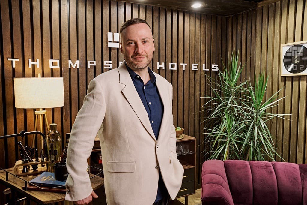 man standing in hotel office smiling at camera