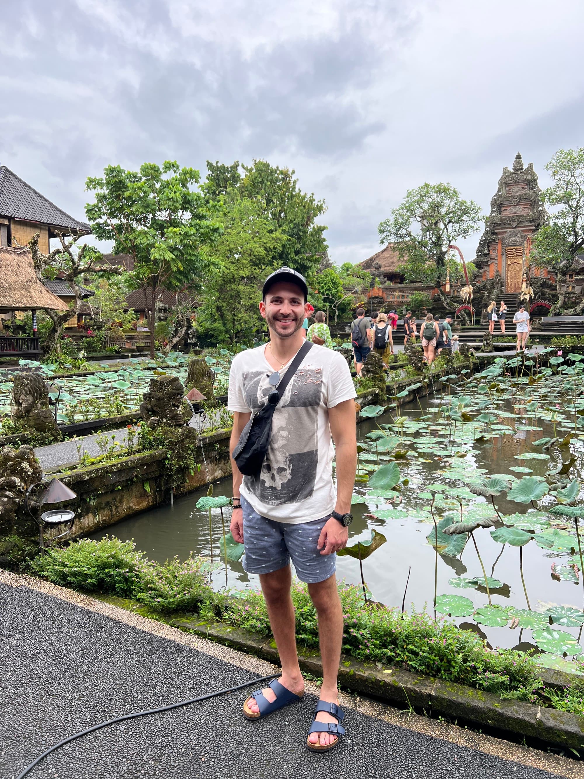 a man in a white shirt stands in front of ancient temples