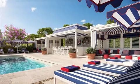 a luxe outdoor pool surrounded by striped loungers
