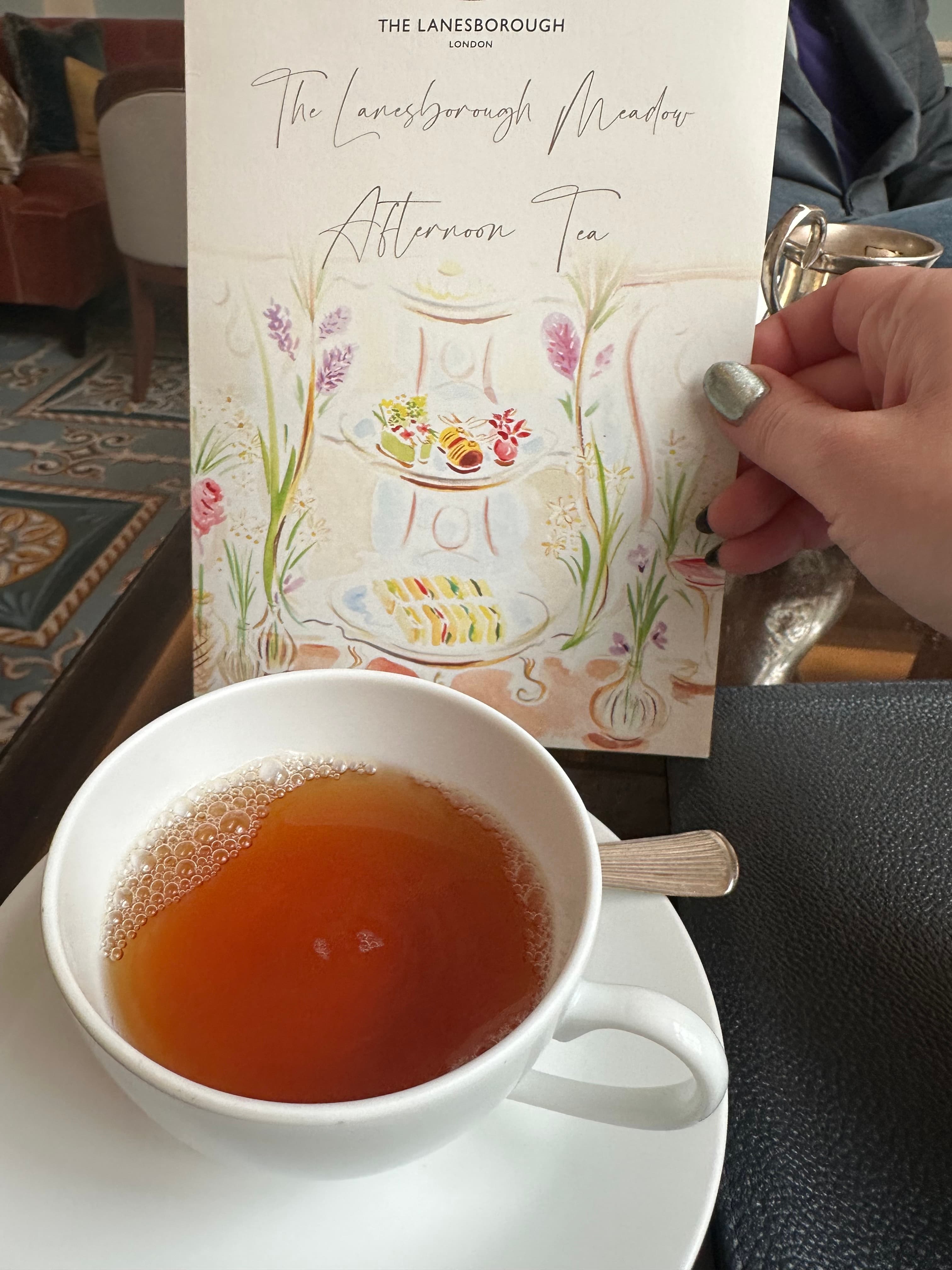 A picture of a cup of tea with a menu titled 'The Lanesborough Menu, Afternoon Tea'.
