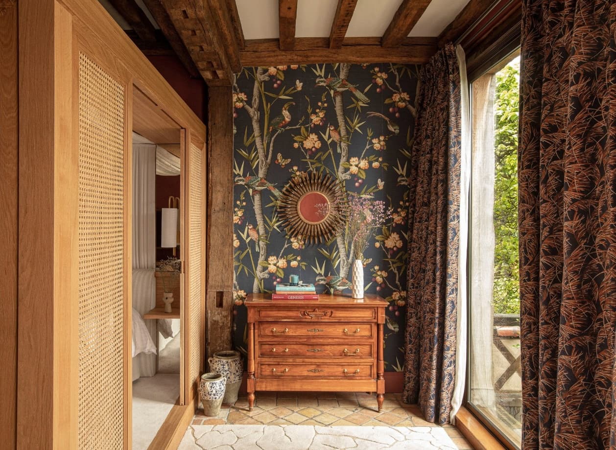 hallway with flowered wallpaper and a wooden chest