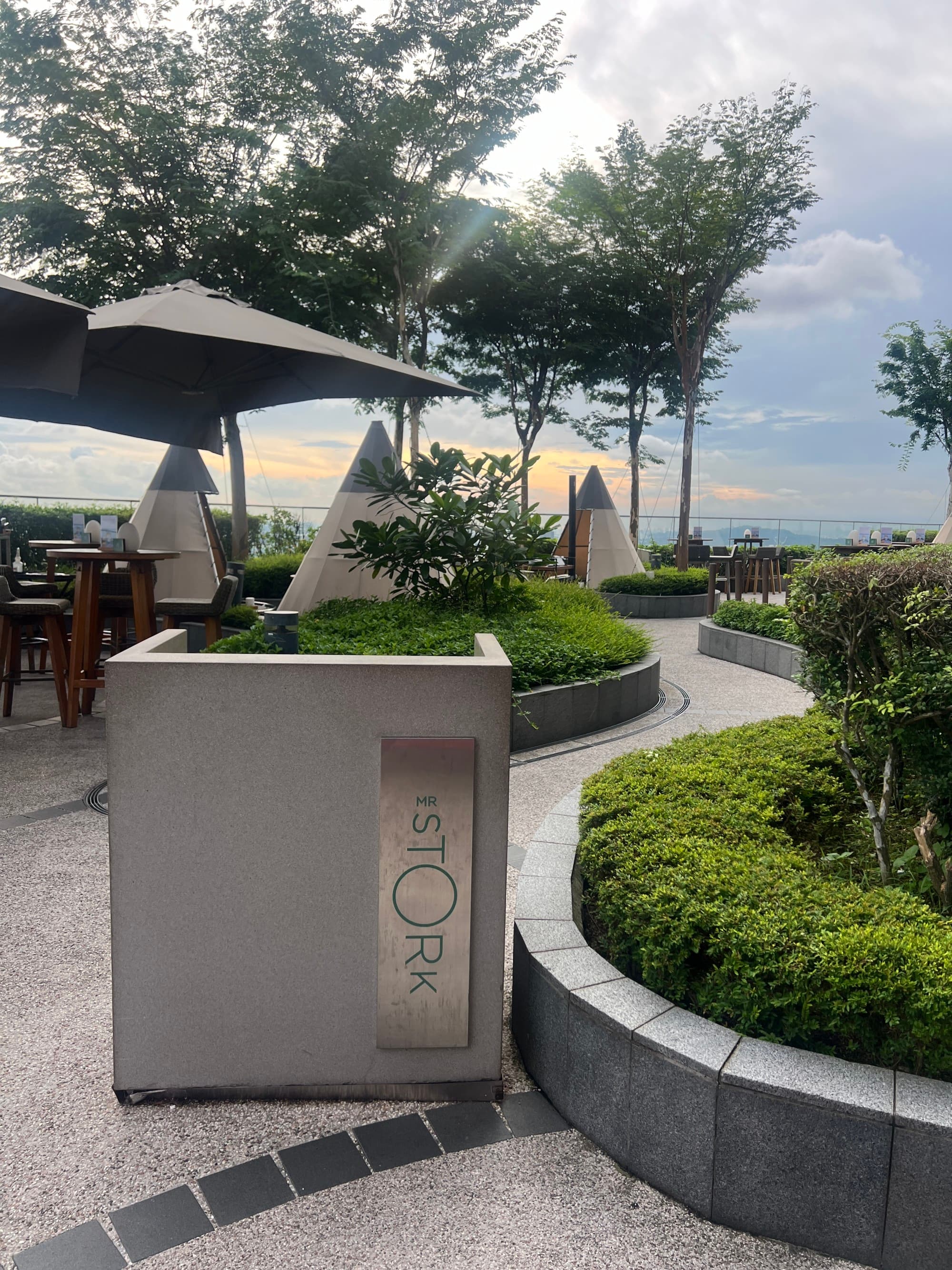 Garden with paved pathways and green umbrellas.