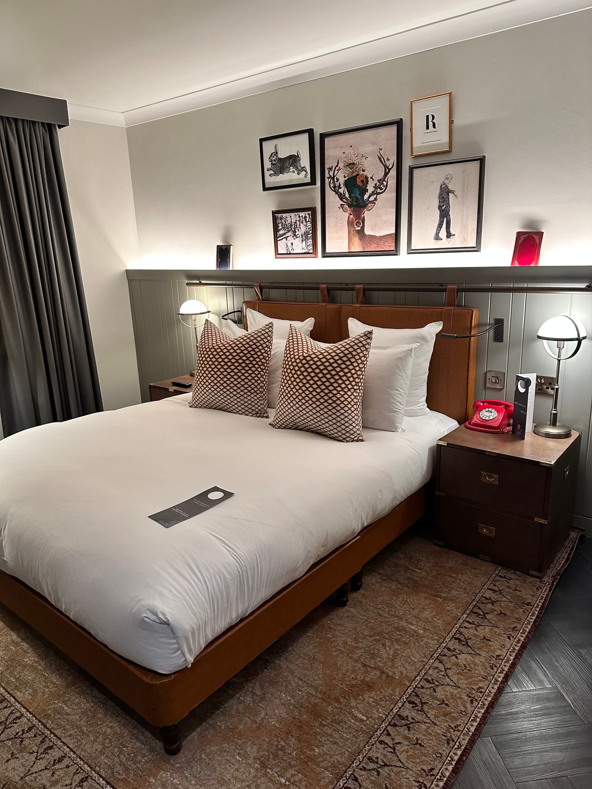 A hotel room with several small photos gramed above the bed.