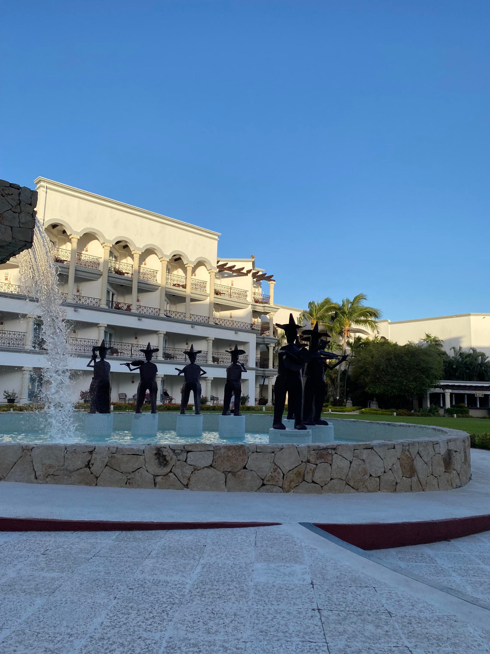 An outdoor water fountain in front of a hotel building during the daytime