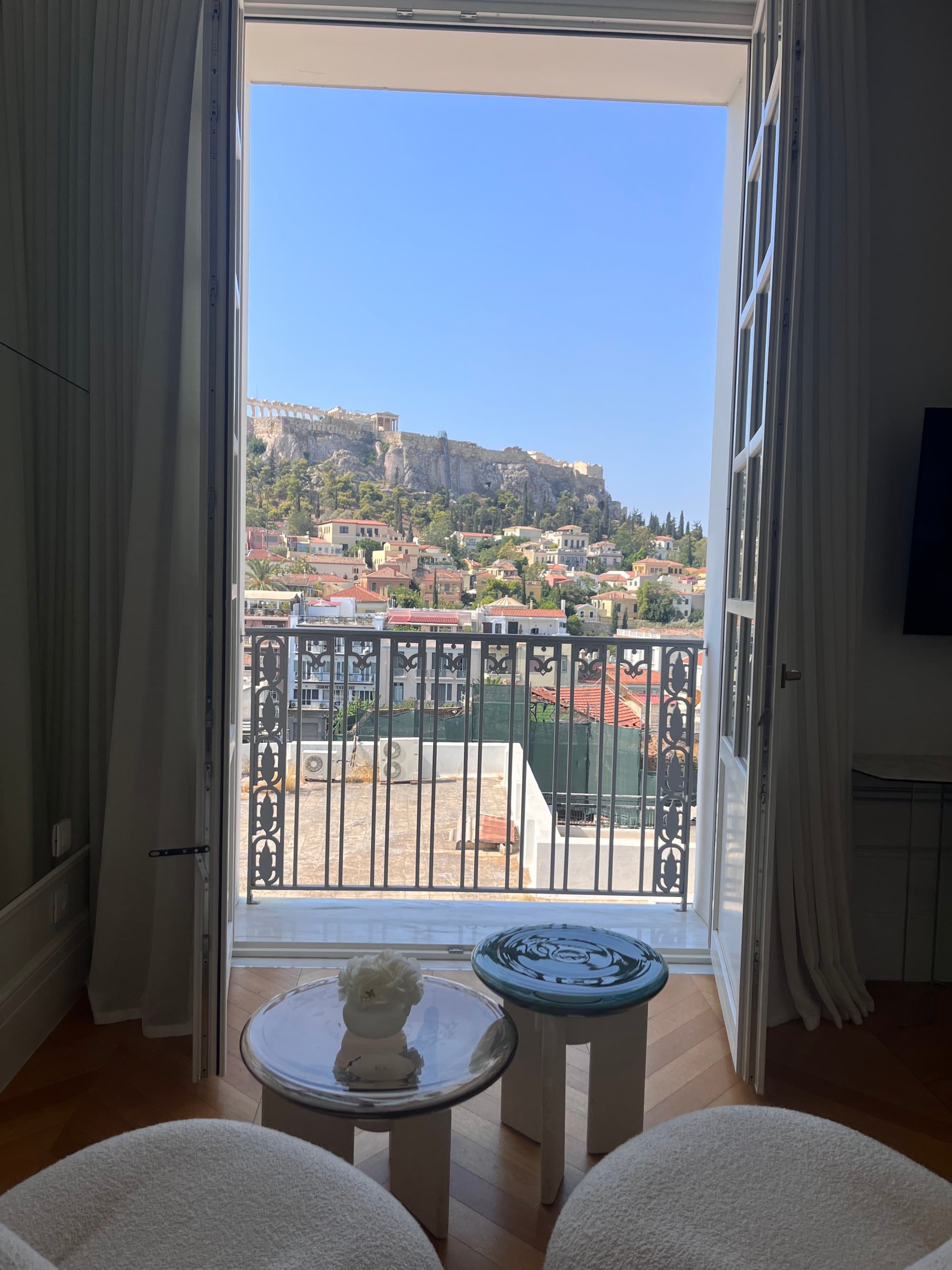 Window view out to the terrace overlooking the seaside town on a sunny day.