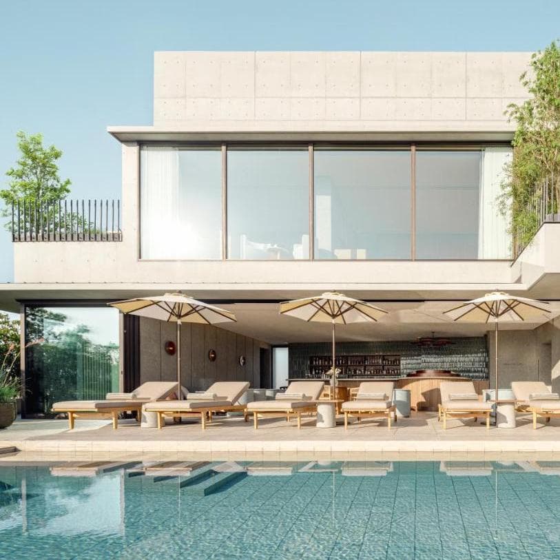 a modern pool courtyard at a sleek hotel on a sunny day