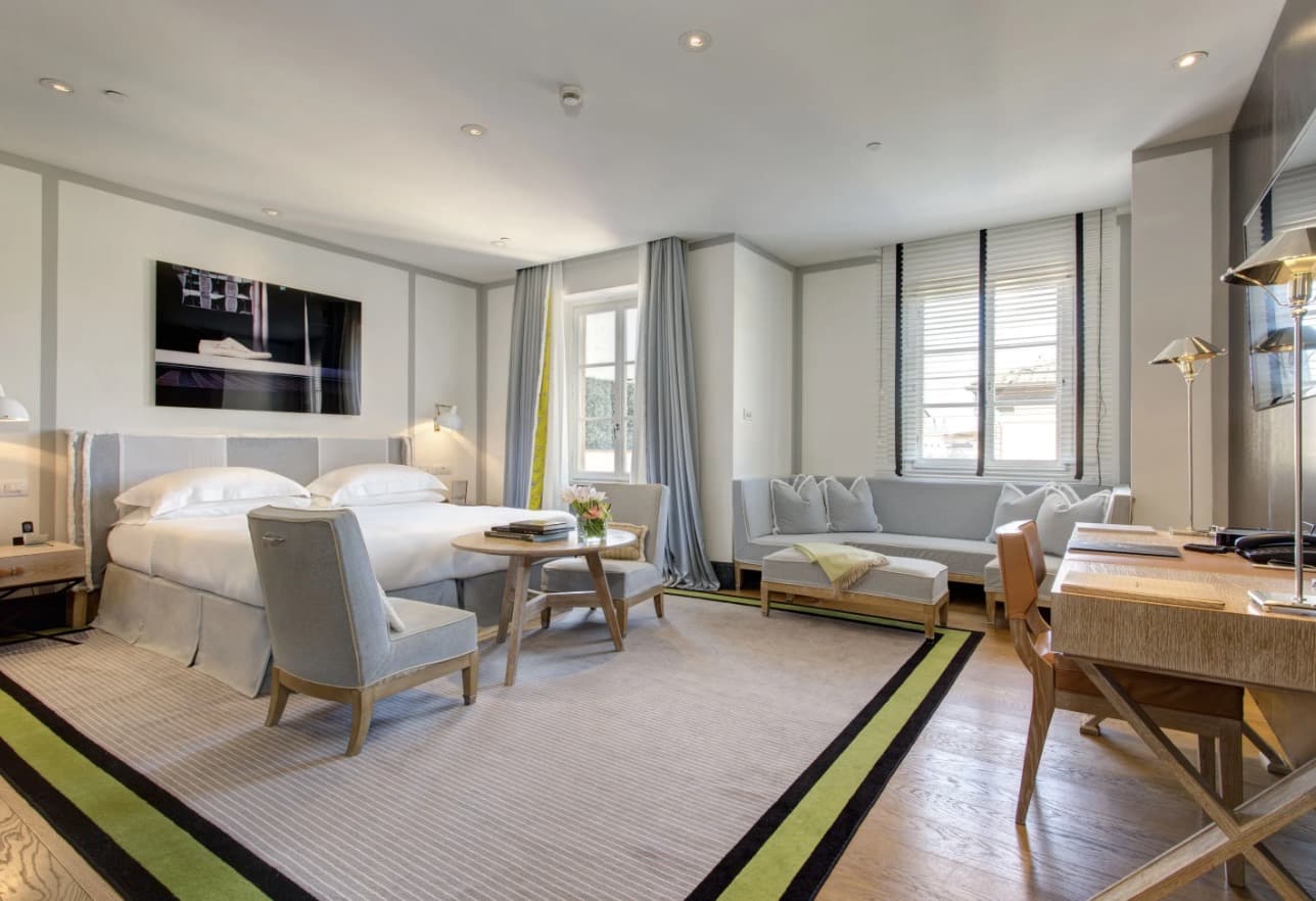 bright bedroom with a desk, sofa and chairs