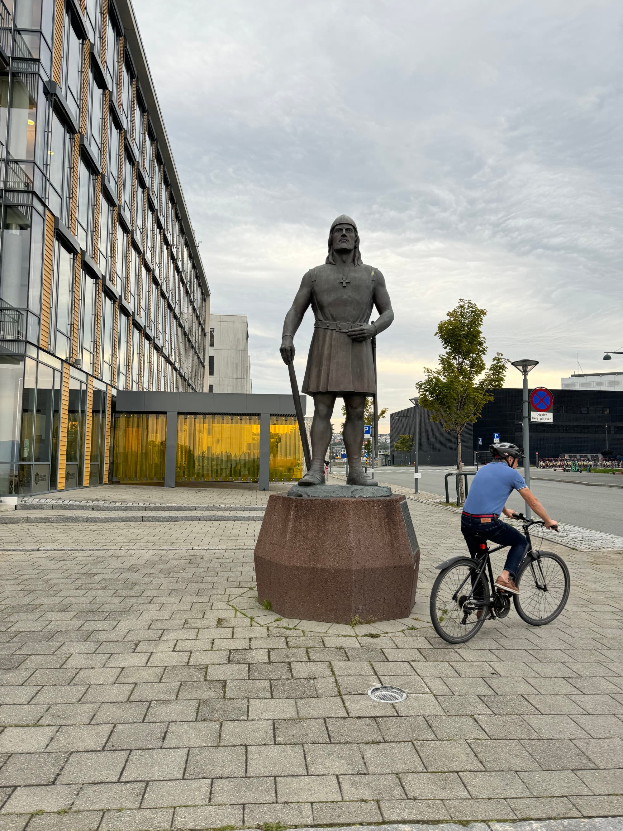 A child on a bike cycling around a statue of a person